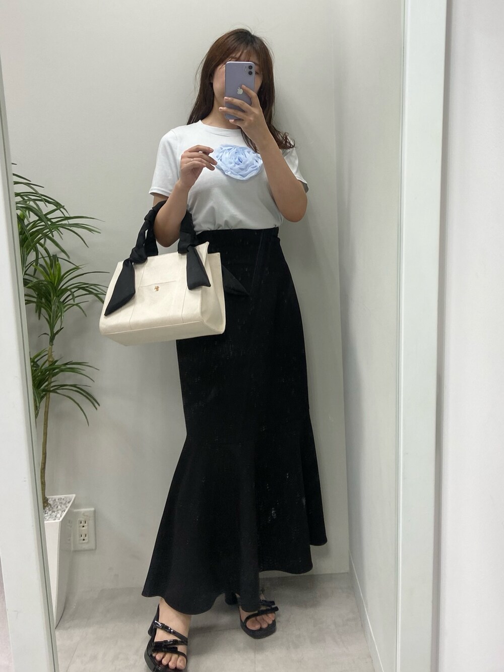 ホワイト系のトートバッグ、シルバー系のサンダル、ブラック系のスカートを着用したレディースの夏コーディネートの3枚目の写真