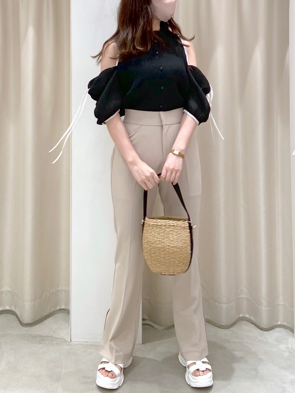 ブラック系のシャツ/ブラウス、ブラック系のショルダーバッグ、ベージュ系のスラックスを着用したレディースの春コーディネートの3枚目の写真