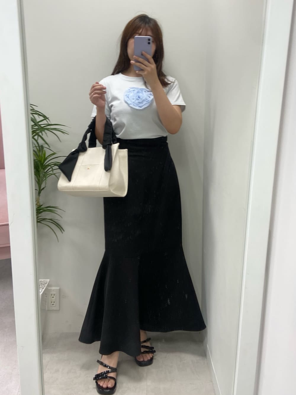 ホワイト系のトートバッグ、シルバー系のサンダル、ブラック系のスカートを着用したレディースの夏コーディネートの4枚目の写真