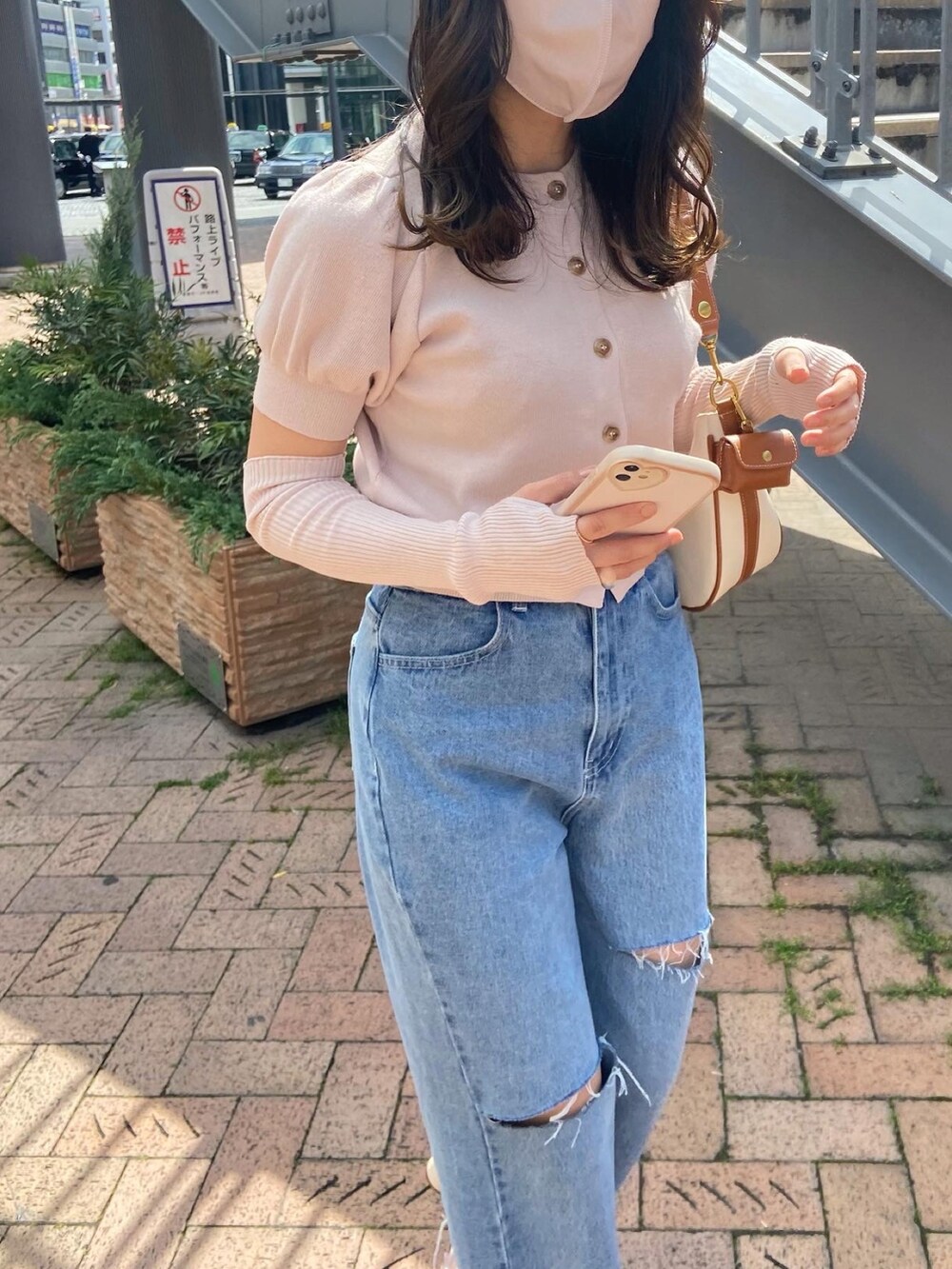 ピンク系のニット/セーター、ブルー系のデニムパンツ、ホワイト系のショルダーバッグを着用したレディースの春コーディネートの4枚目の写真
