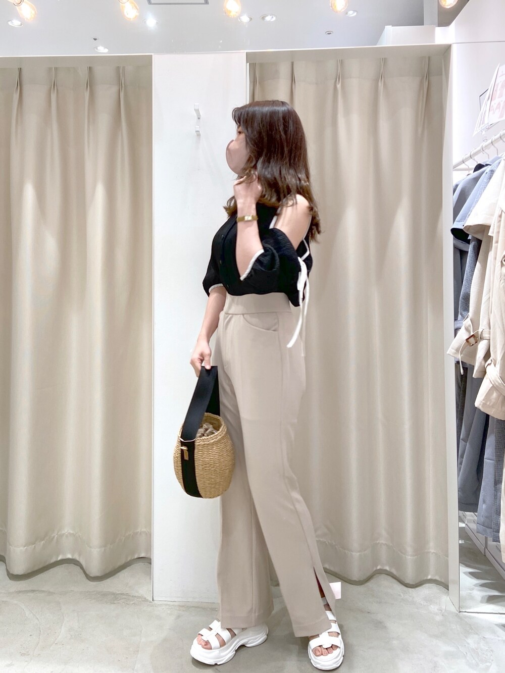 ブラック系のシャツ/ブラウス、ブラック系のショルダーバッグ、ベージュ系のスラックスを着用したレディースの春コーディネートの4枚目の写真