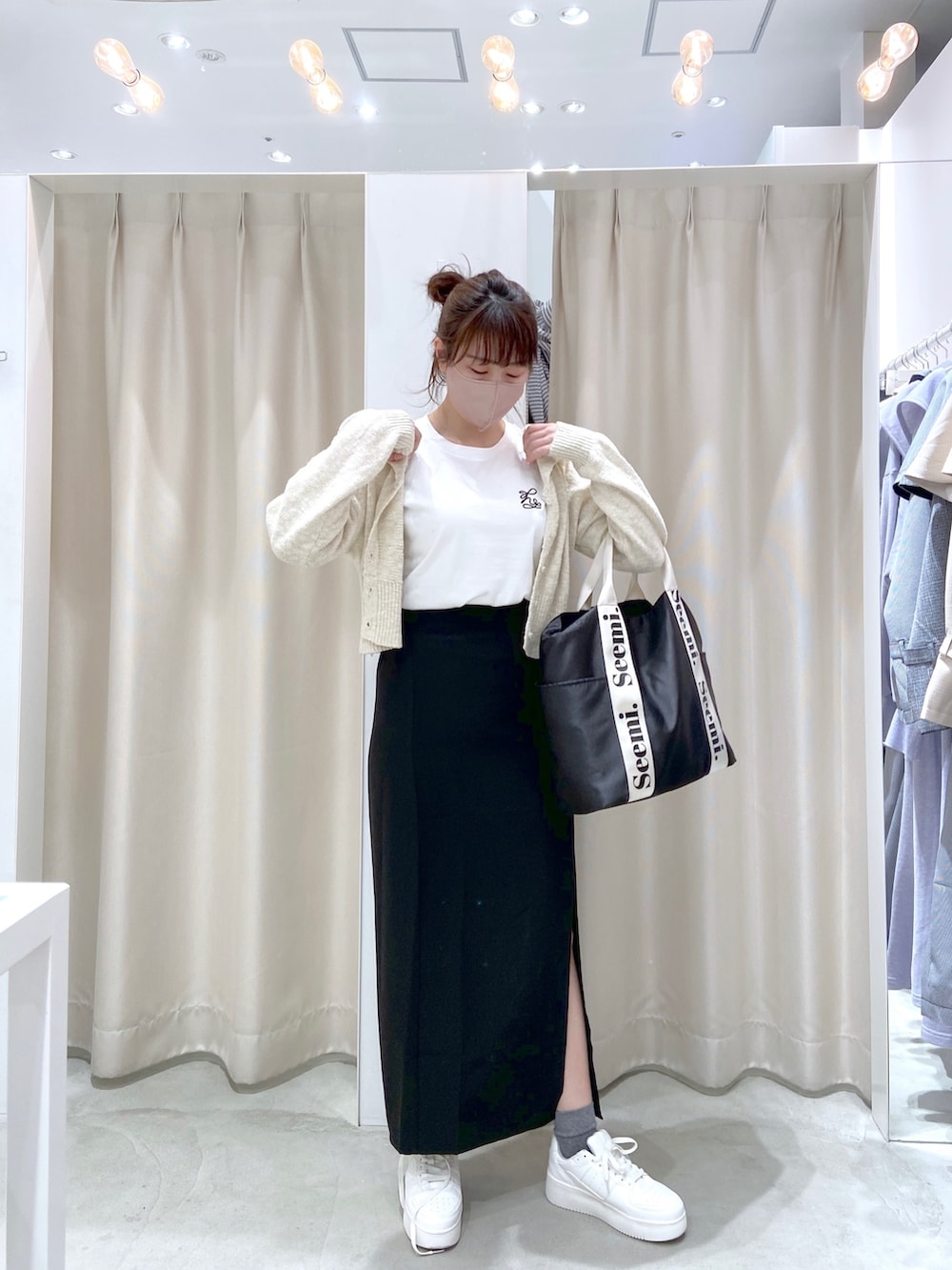 ホワイト系のカーディガン/ボレロ、ホワイト系のTシャツ/カットソー、ブラック系のトートバッグを着用したレディースの春コーディネートの4枚目の写真