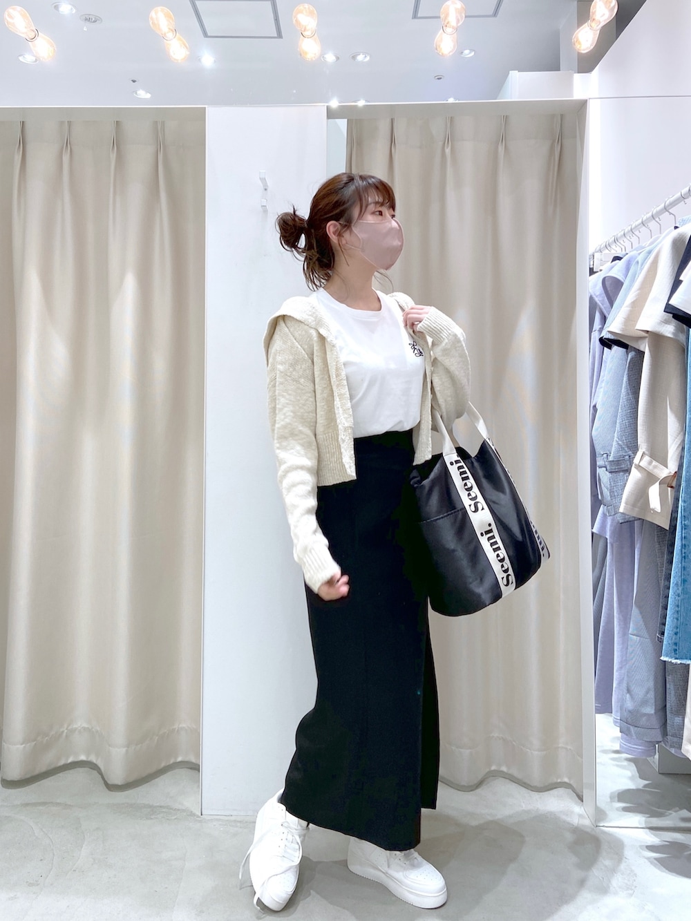 ホワイト系のカーディガン/ボレロ、ホワイト系のTシャツ/カットソー、ブラック系のトートバッグを着用したレディースの春コーディネートの3枚目の写真