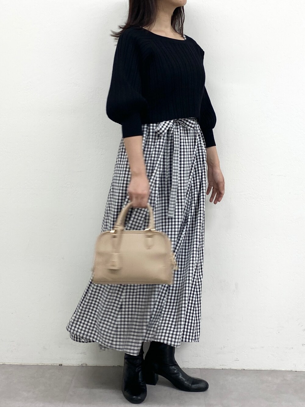 ブラック系のワンピースを着用したレディースの冬コーディネートの2枚目の写真