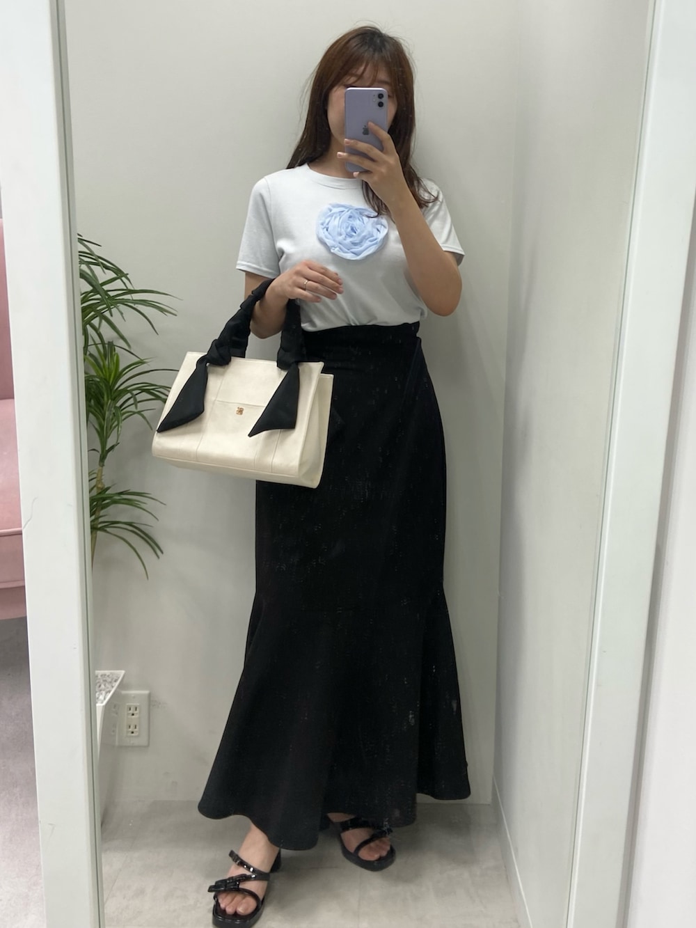 ホワイト系のトートバッグ、シルバー系のサンダル、ブラック系のスカートを着用したレディースの夏コーディネートの5枚目の写真