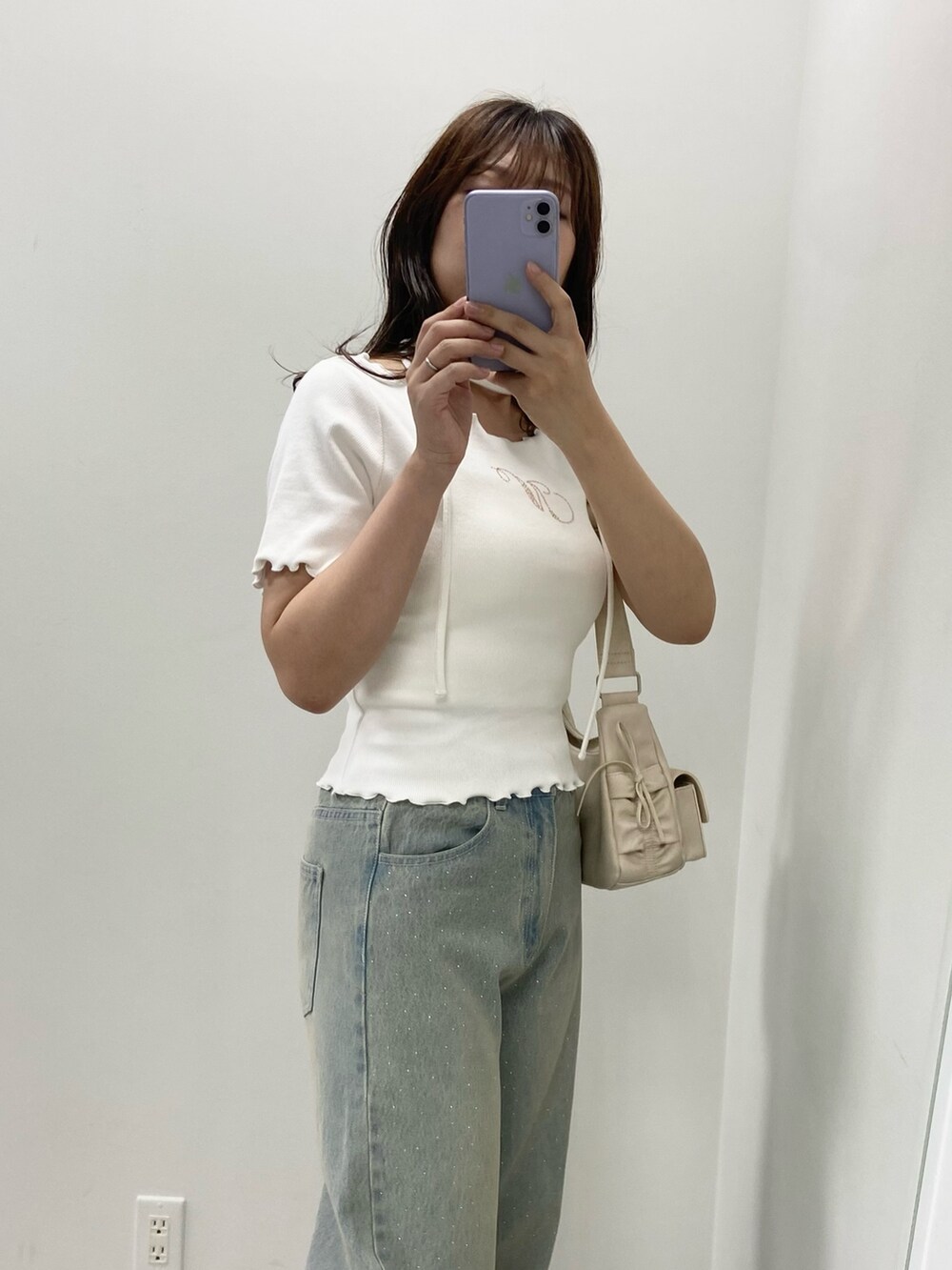 ピンク系のショルダーバッグ、ブルー系のデニムパンツ、ホワイト系のTシャツ/カットソーを着用したレディースの夏コーディネートの2枚目の写真