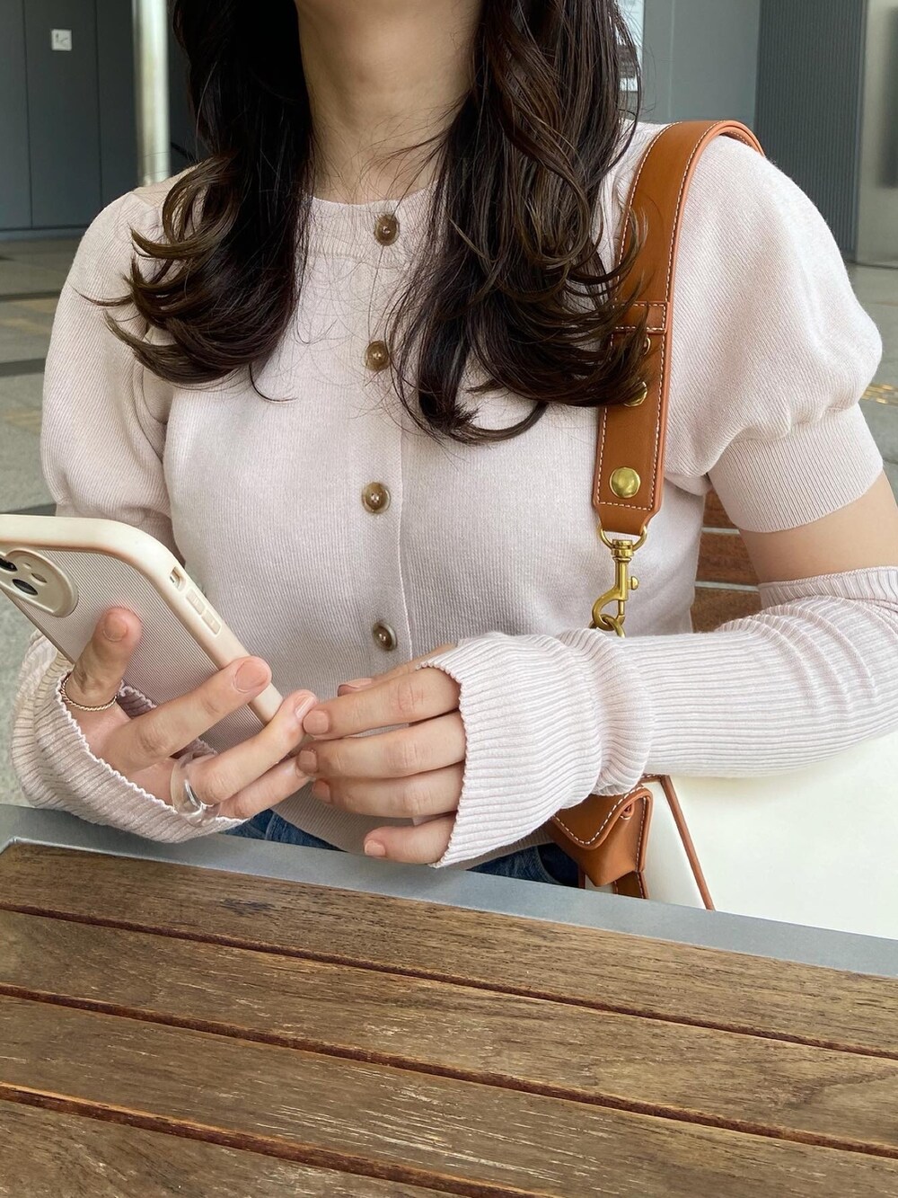 ピンク系のニット/セーター、ブルー系のデニムパンツ、ホワイト系のショルダーバッグを着用したレディースの春コーディネートの5枚目の写真