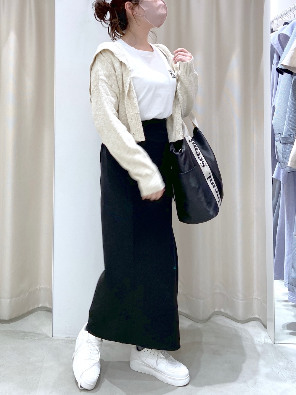 ホワイト系のカーディガン/ボレロ、ホワイト系のTシャツ/カットソー、ブラック系のトートバッグを着用したレディースの春コーディネートの2枚目の写真