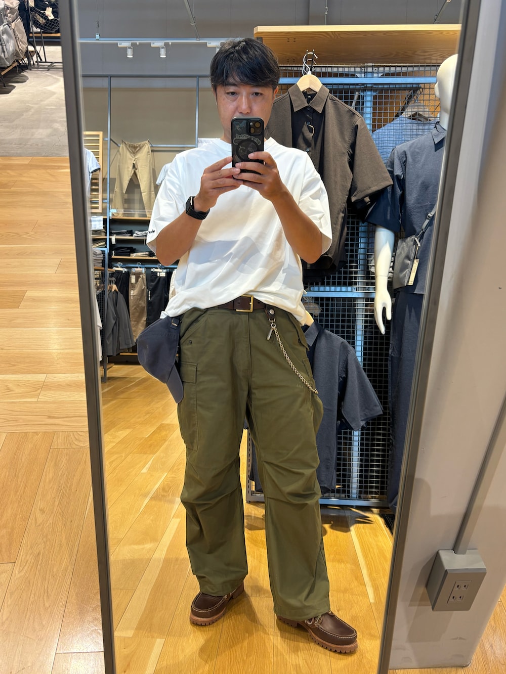 グリーン系のカーゴパンツ、ホワイト系のTシャツ/カットソー、ブラウン系のモカシン/デッキシューズを着用したメンズの夏コーディネートの3枚目の写真