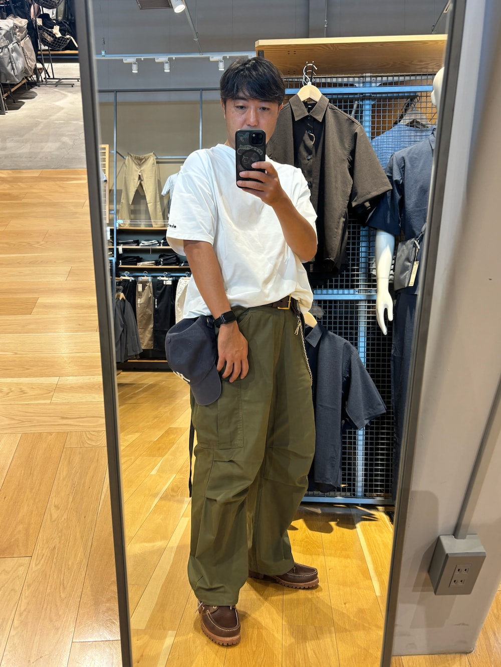 グリーン系のカーゴパンツ、ホワイト系のTシャツ/カットソー、ブラウン系のモカシン/デッキシューズを着用したメンズの夏コーディネートの2枚目の写真