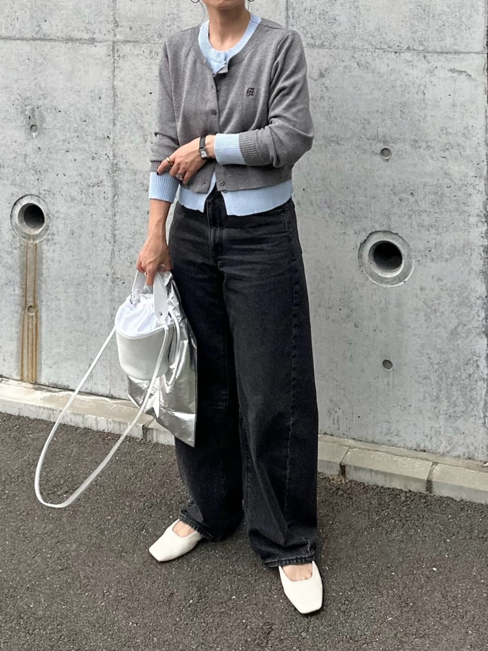 ブラック系のデニムパンツ、ホワイト系のシューズ、グレー系のカーディガン/ボレロを着用したレディースの秋コーディネートの3枚目の写真