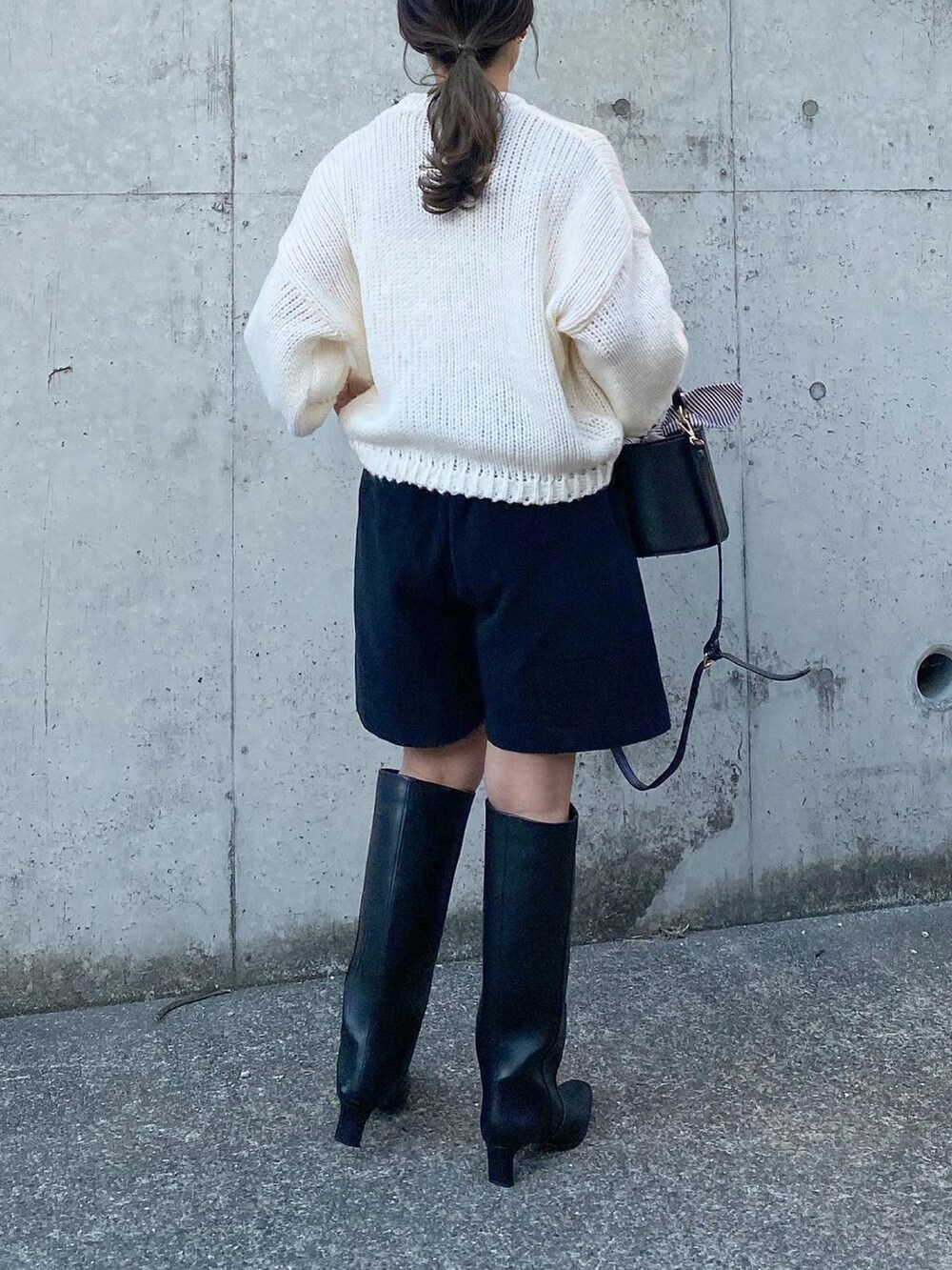 ブラック系のパンツ、ブルー系のニット/セーター、ホワイト系のシューズを着用したレディースの秋コーディネートの4枚目の写真