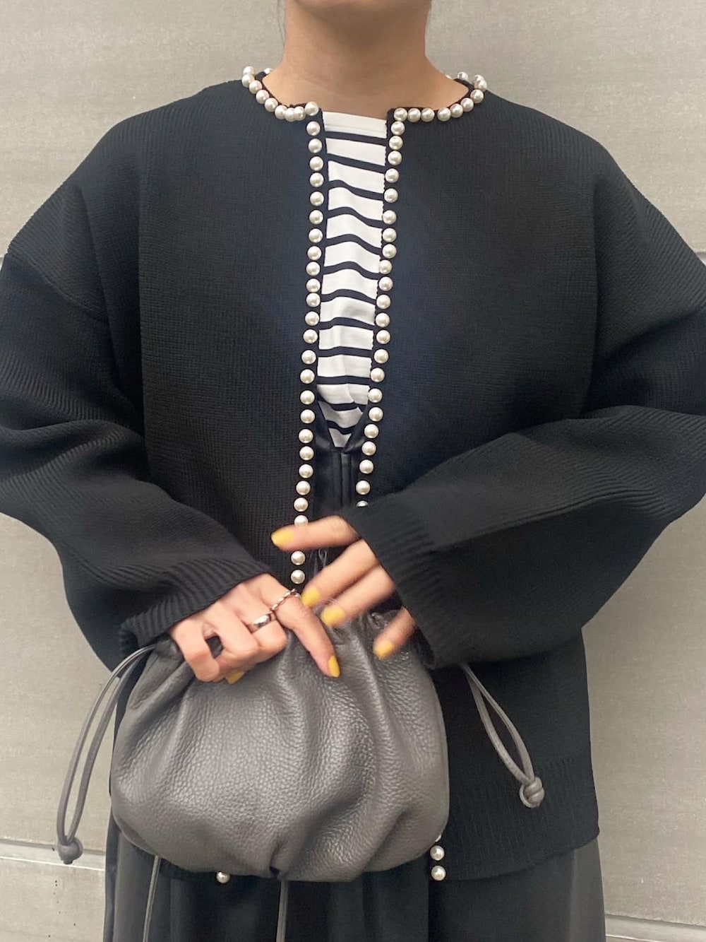 ブラック系のカーディガン/ボレロ、ブラック系のワンピース/ドレス、グレー系のバッグを着用したレディースの冬コーディネートの5枚目の写真