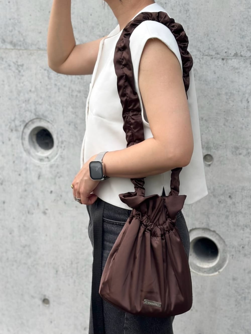 ブラック系のデニムパンツ、ホワイト系のサンダル、ホワイト系のトップスを着用したレディースの夏コーディネートの4枚目の写真