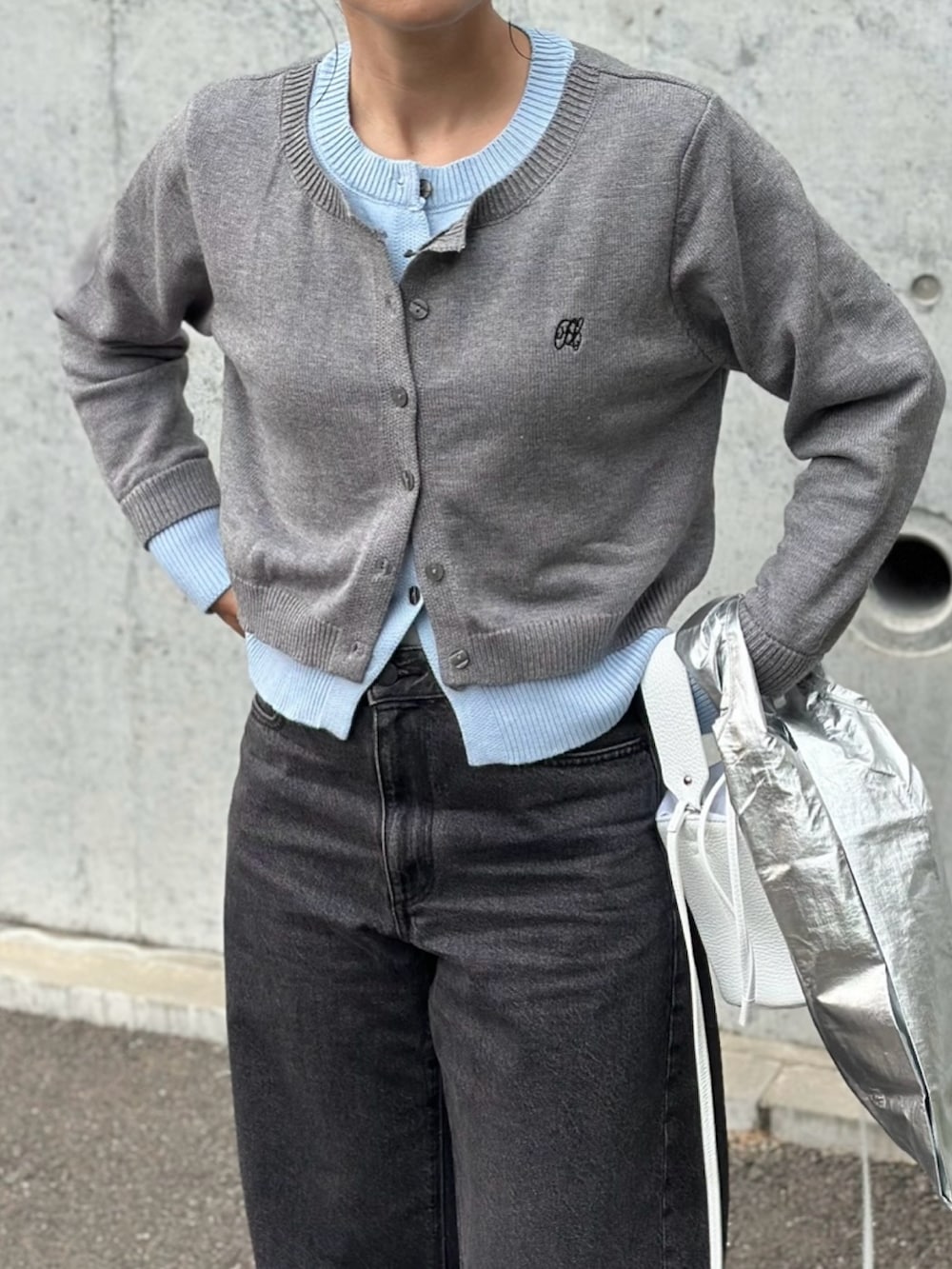 ブラック系のデニムパンツ、ホワイト系のシューズ、グレー系のカーディガン/ボレロを着用したレディースの秋コーディネートの4枚目の写真