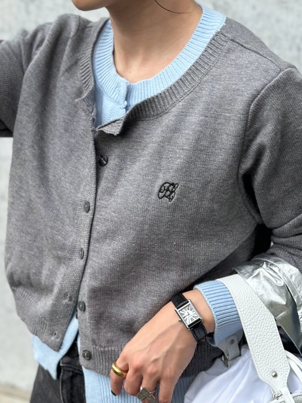 ブラック系のデニムパンツ、ホワイト系のシューズ、グレー系のカーディガン/ボレロを着用したレディースの秋コーディネートの5枚目の写真