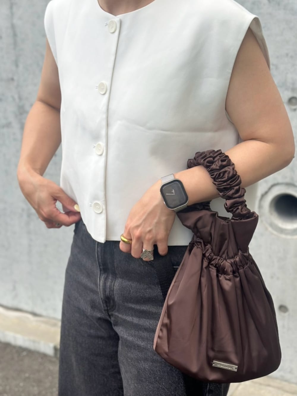 ブラック系のデニムパンツ、ホワイト系のサンダル、ホワイト系のトップスを着用したレディースの夏コーディネートの3枚目の写真