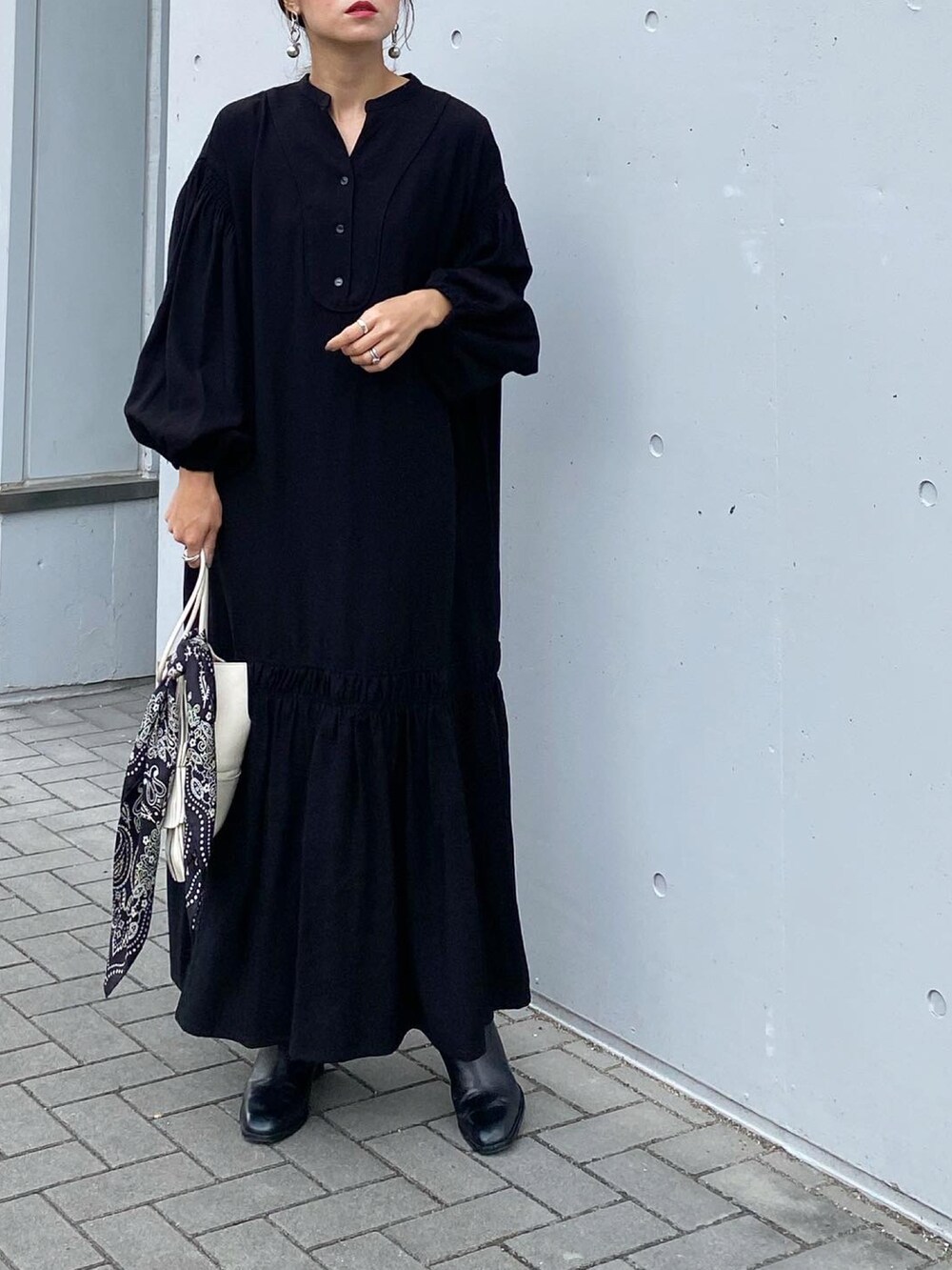 ブラック系のブーツ、ブラック系のワンピース、ホワイト系のショルダーバッグを着用したレディースの秋コーディネートの4枚目の写真