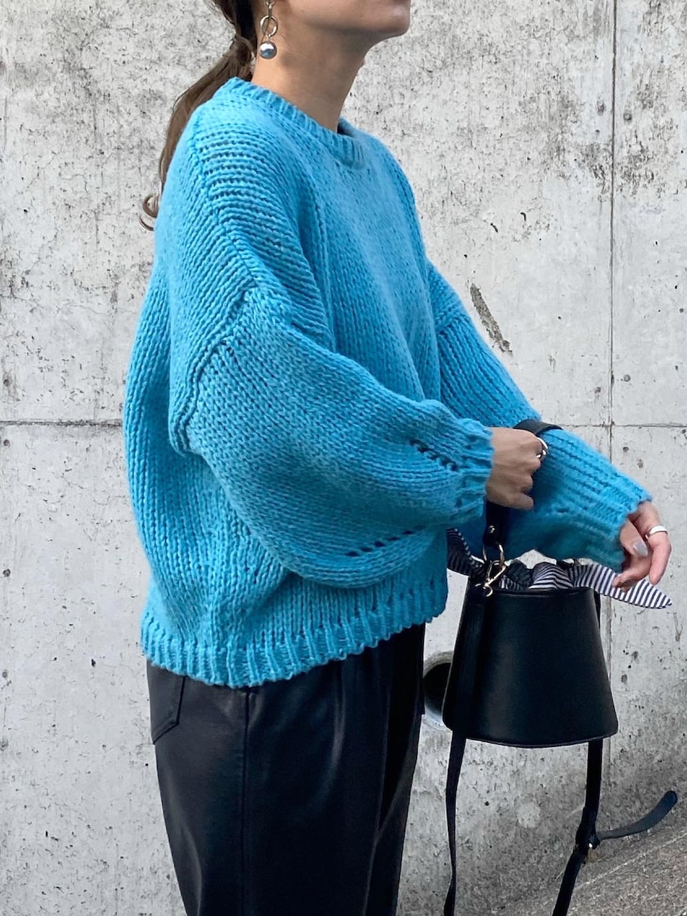 ブラック系のパンツ、ブルー系のニット/セーター、ホワイト系のシューズを着用したレディースの秋コーディネートの5枚目の写真