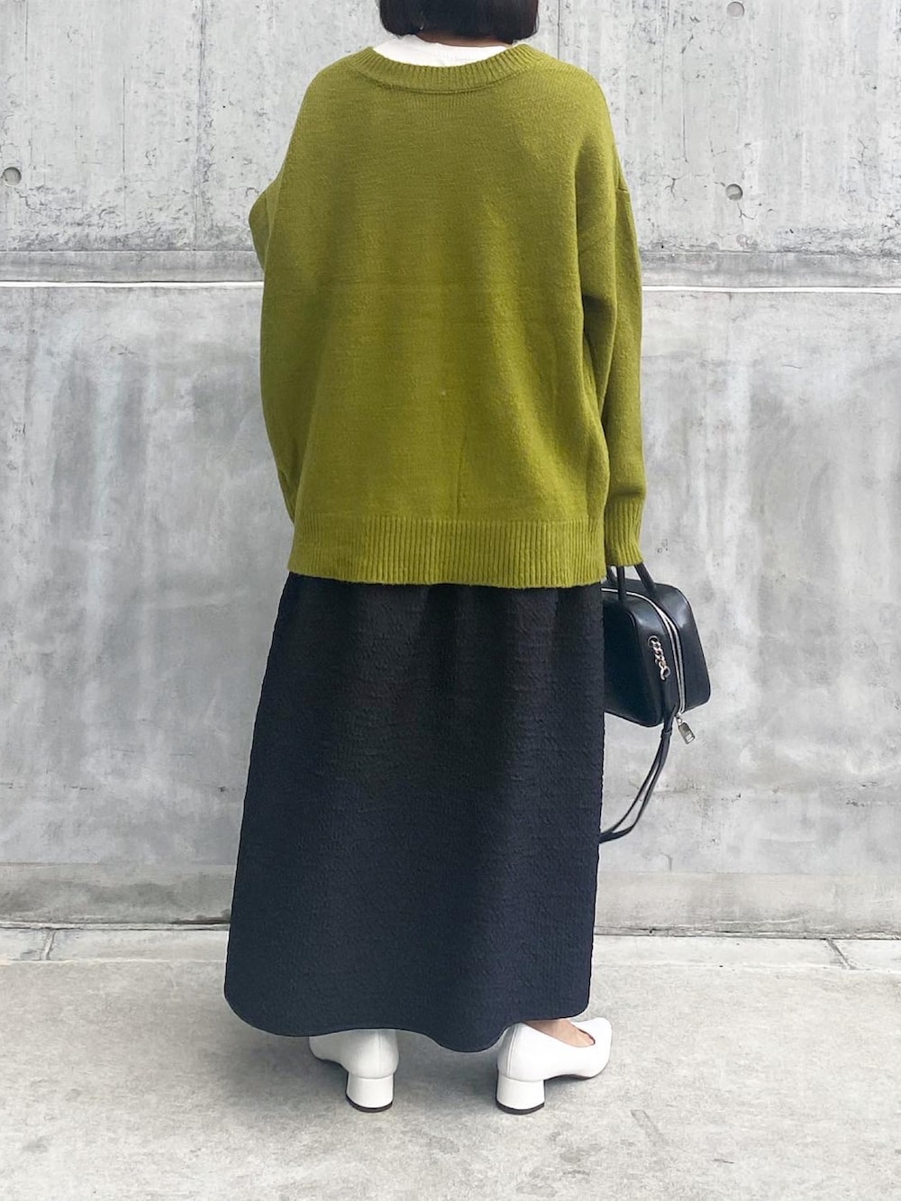 ホワイト系のパンプス、ブラック系のスカート、ブラック系のバッグを着用したレディースの秋コーディネートの5枚目の写真