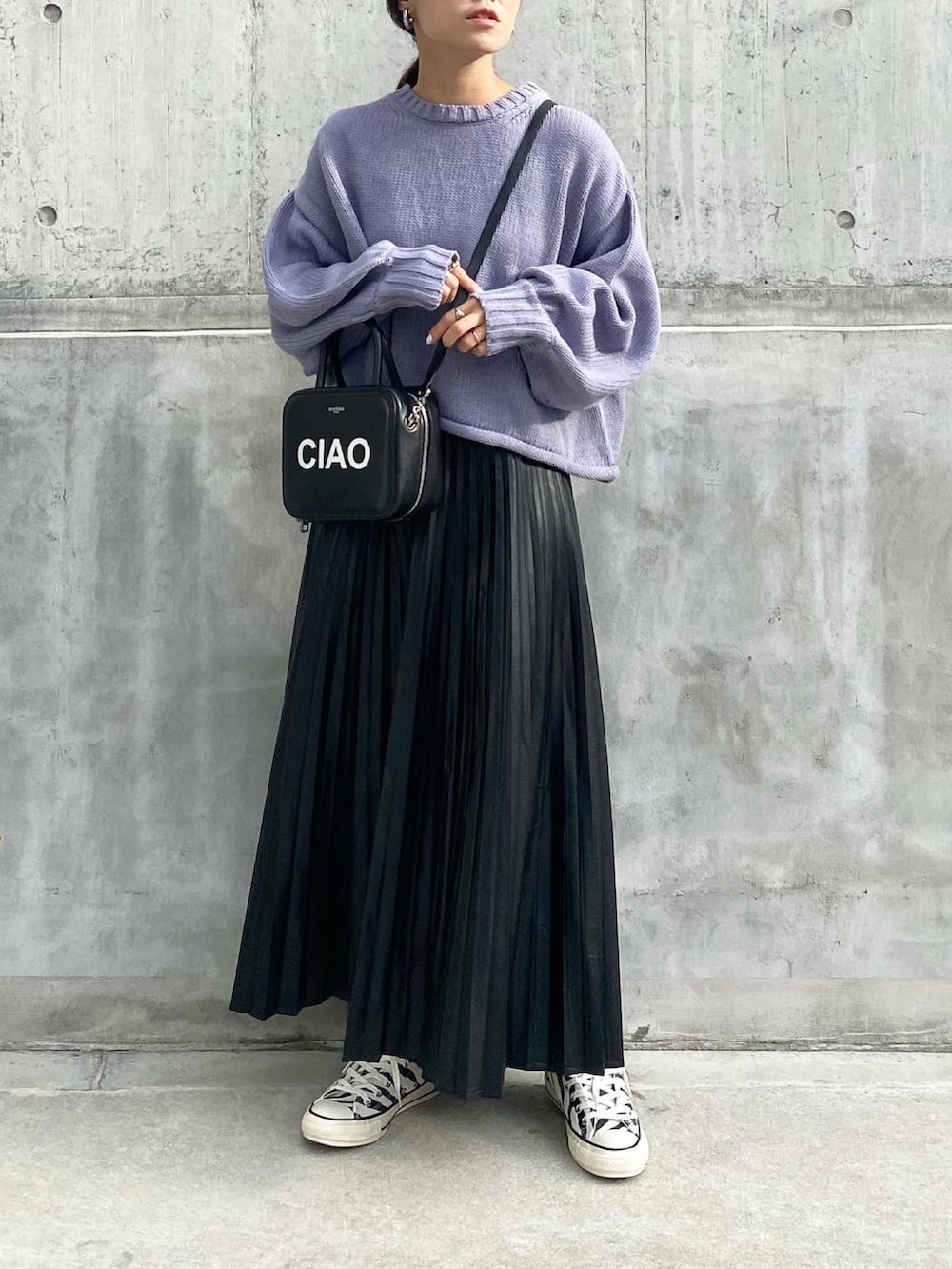 ブラック系のバッグ、ブラック系のスカート、ブラック系のスニーカーを着用したレディースの秋コーディネートの3枚目の写真