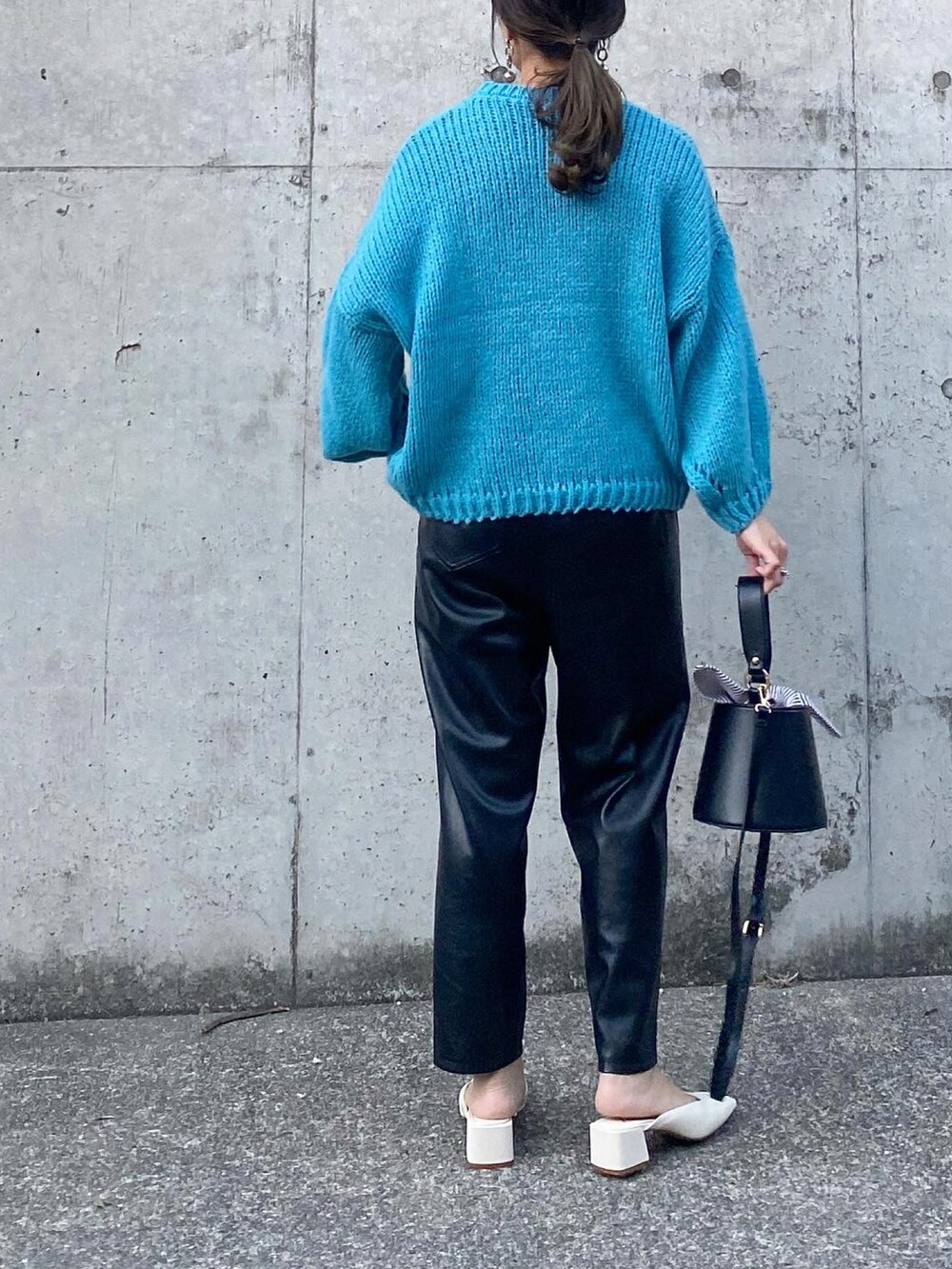 ブラック系のパンツ、ブルー系のニット/セーター、ホワイト系のシューズを着用したレディースの秋コーディネートの2枚目の写真