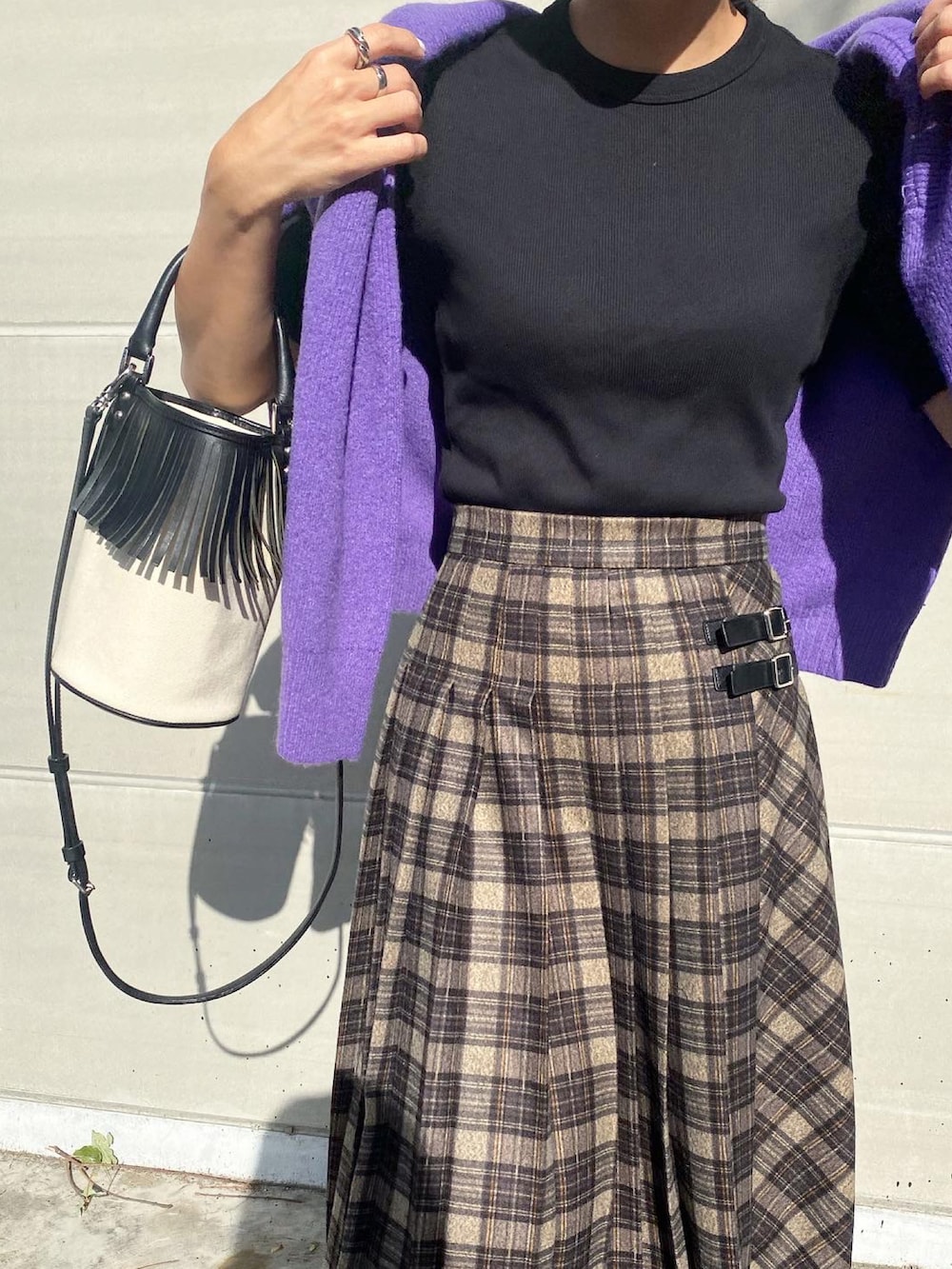 グレー系のスカート、ブラック系のブーツ、ホワイト系のバッグを着用したレディースの秋コーディネートの5枚目の写真