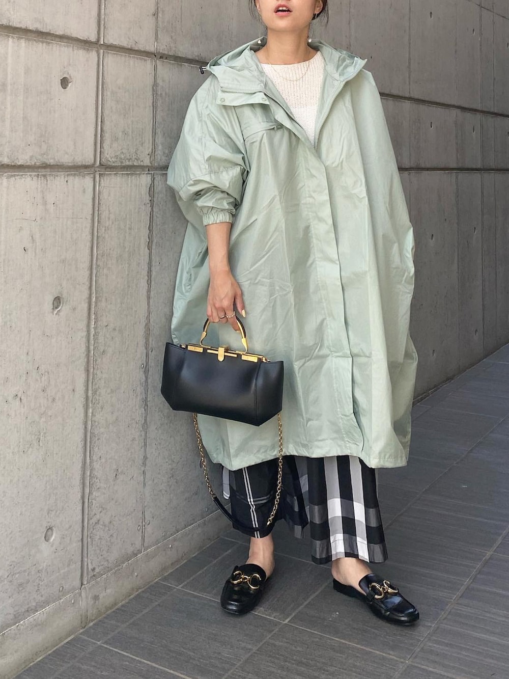 ブラック系のハンドバッグ、ブラック系のスカート、ブラック系のシューズを着用したレディースの春コーディネートの4枚目の写真