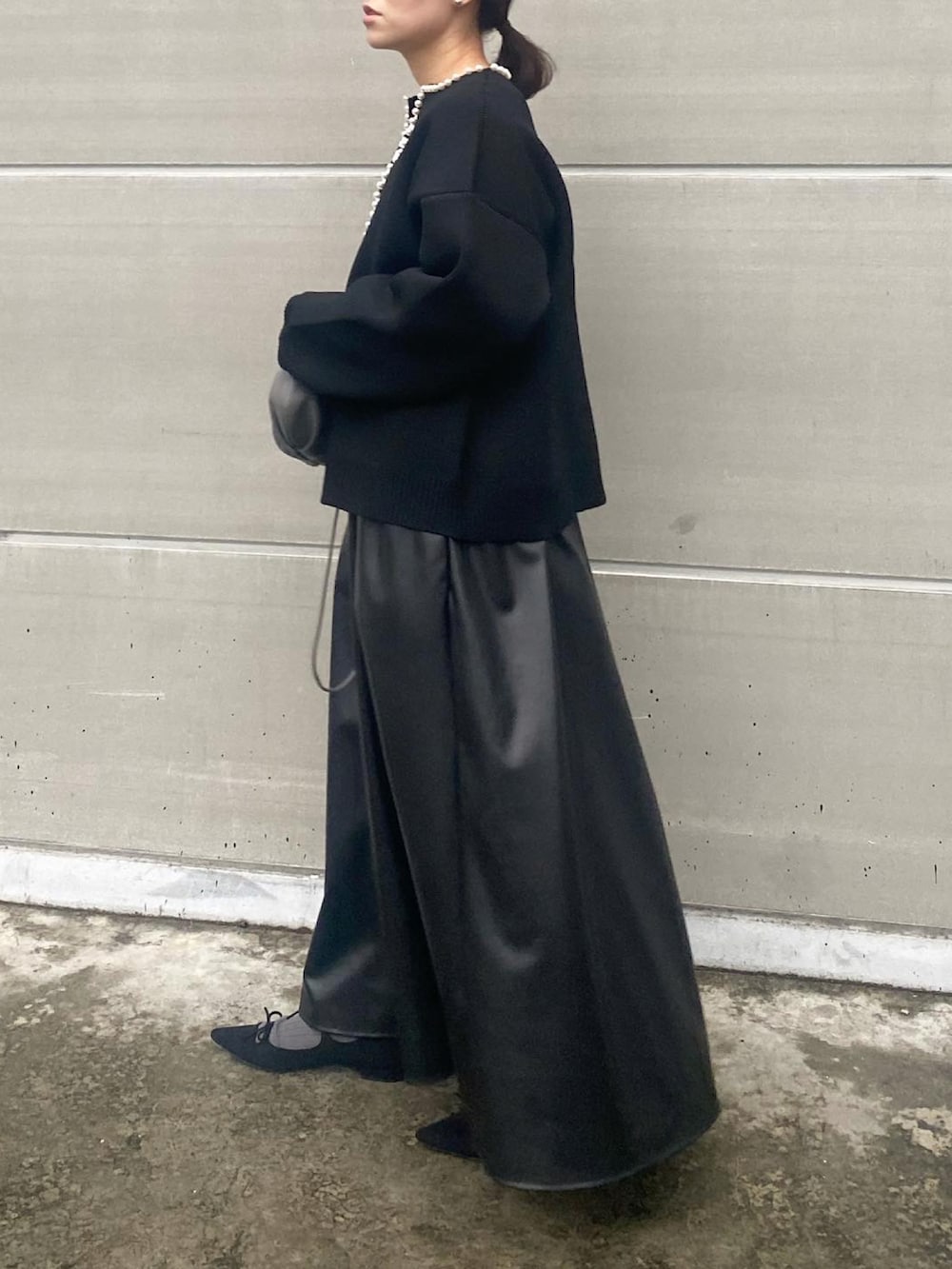 ブラック系のカーディガン/ボレロ、ブラック系のワンピース/ドレス、グレー系のバッグを着用したレディースの冬コーディネートの2枚目の写真