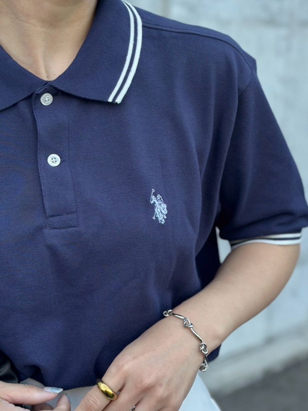 ブラック系のその他シューズ、ブラック系のショルダーバッグ、ブルー系のポロシャツを着用したレディースの春コーディネートの5枚目の写真