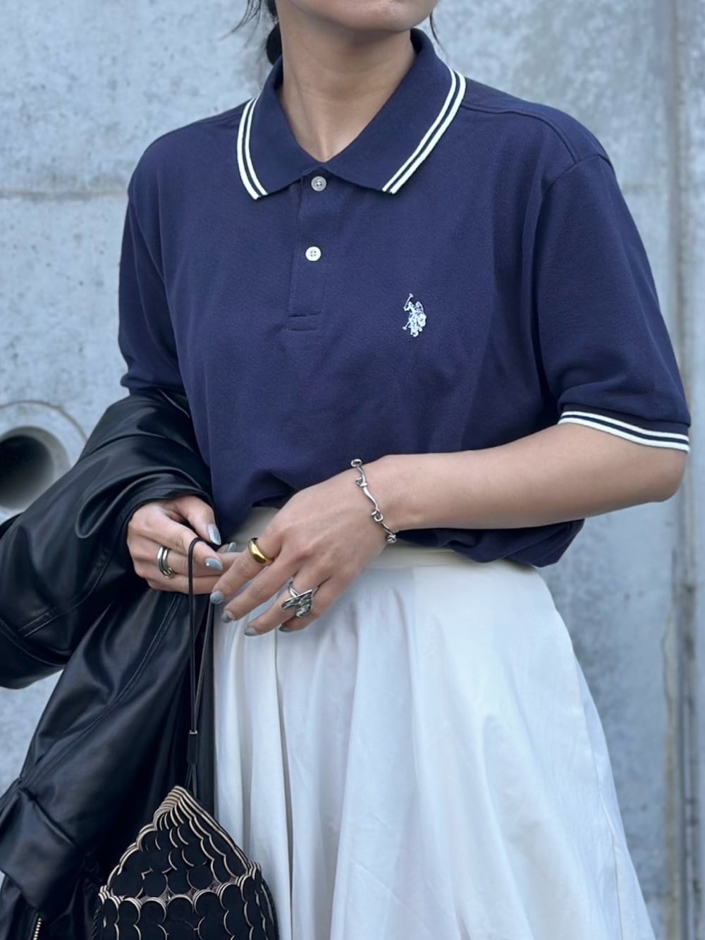 ブラック系のその他シューズ、ブラック系のショルダーバッグ、ブルー系のポロシャツを着用したレディースの春コーディネートの4枚目の写真