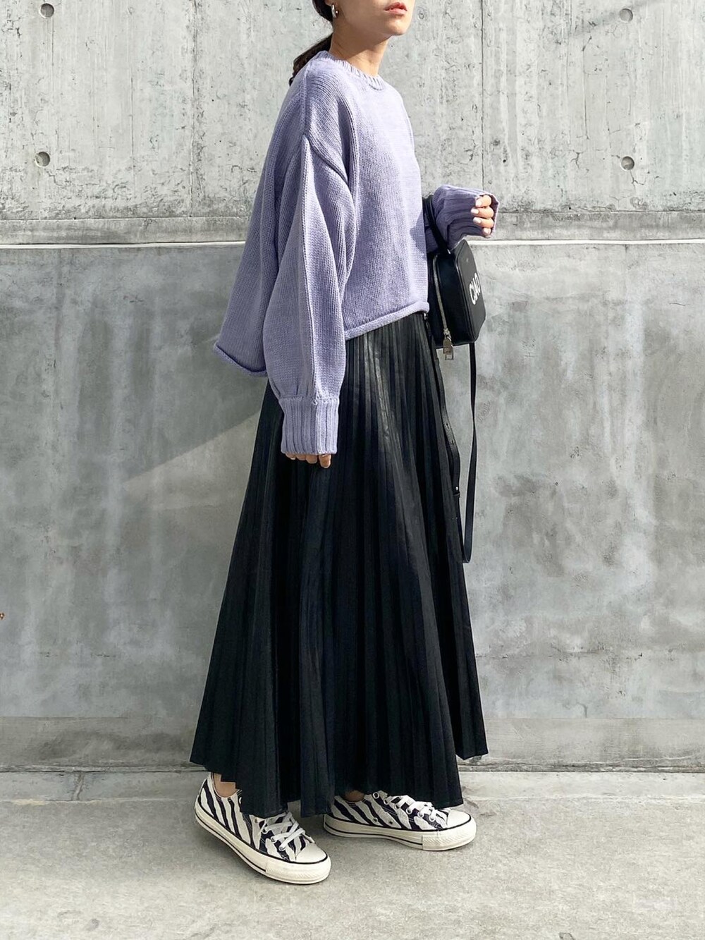 ブラック系のバッグ、ブラック系のスカート、ブラック系のスニーカーを着用したレディースの秋コーディネートの2枚目の写真