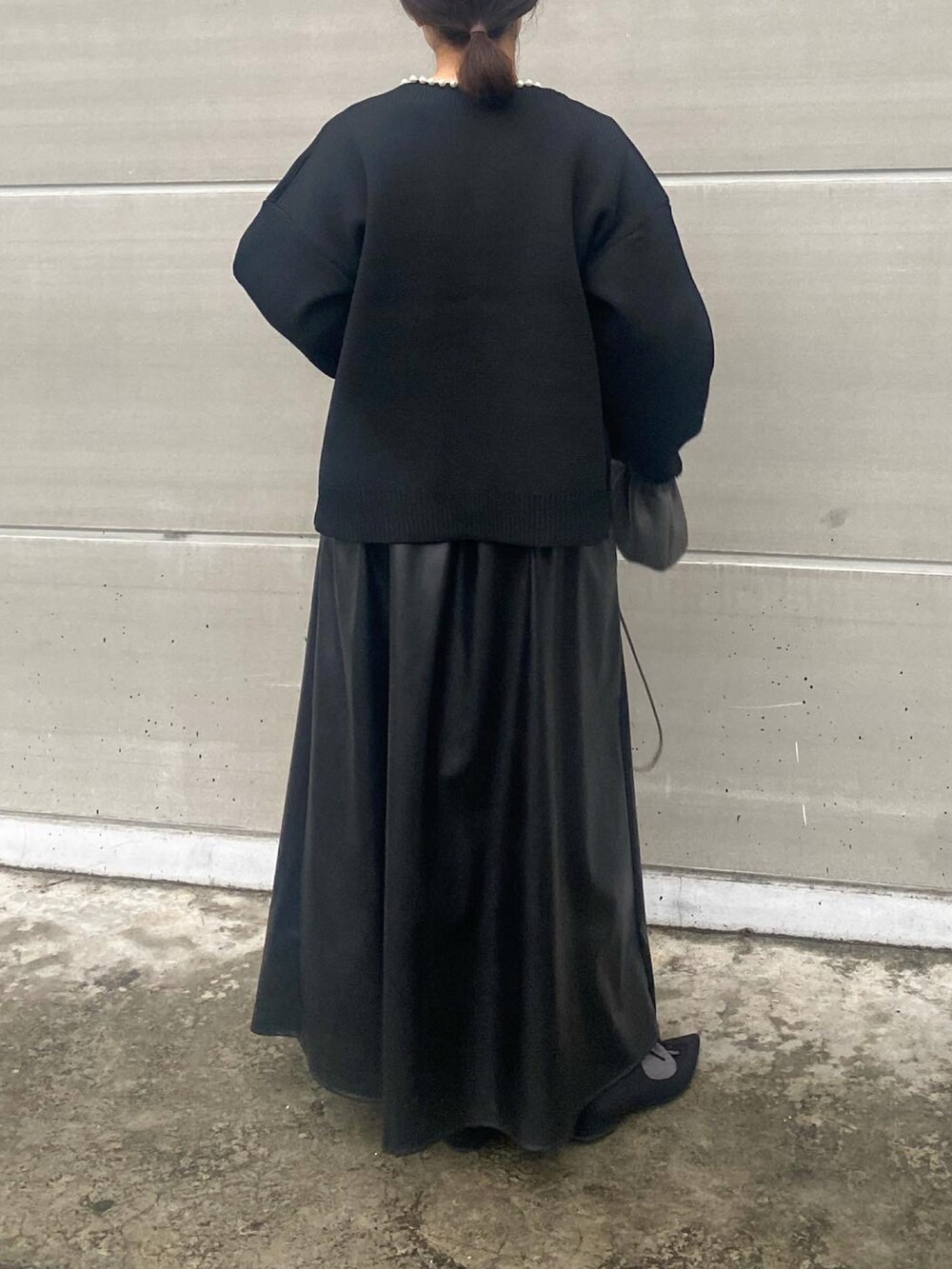 ブラック系のカーディガン/ボレロ、ブラック系のワンピース/ドレス、グレー系のバッグを着用したレディースの冬コーディネートの3枚目の写真