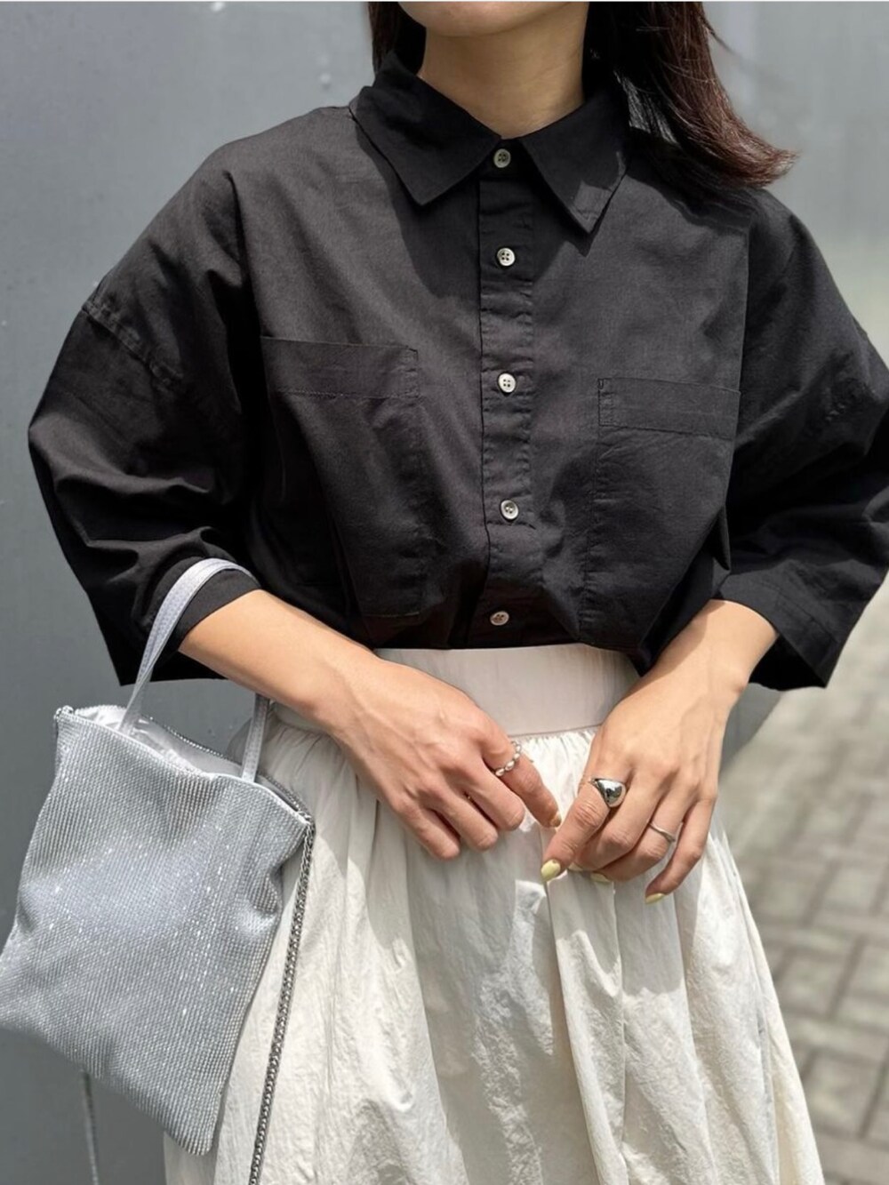 ホワイト系のスカート、ブラック系のシャツ/ブラウス、ブラック系のサンダルを着用したレディースの夏コーディネートの4枚目の写真