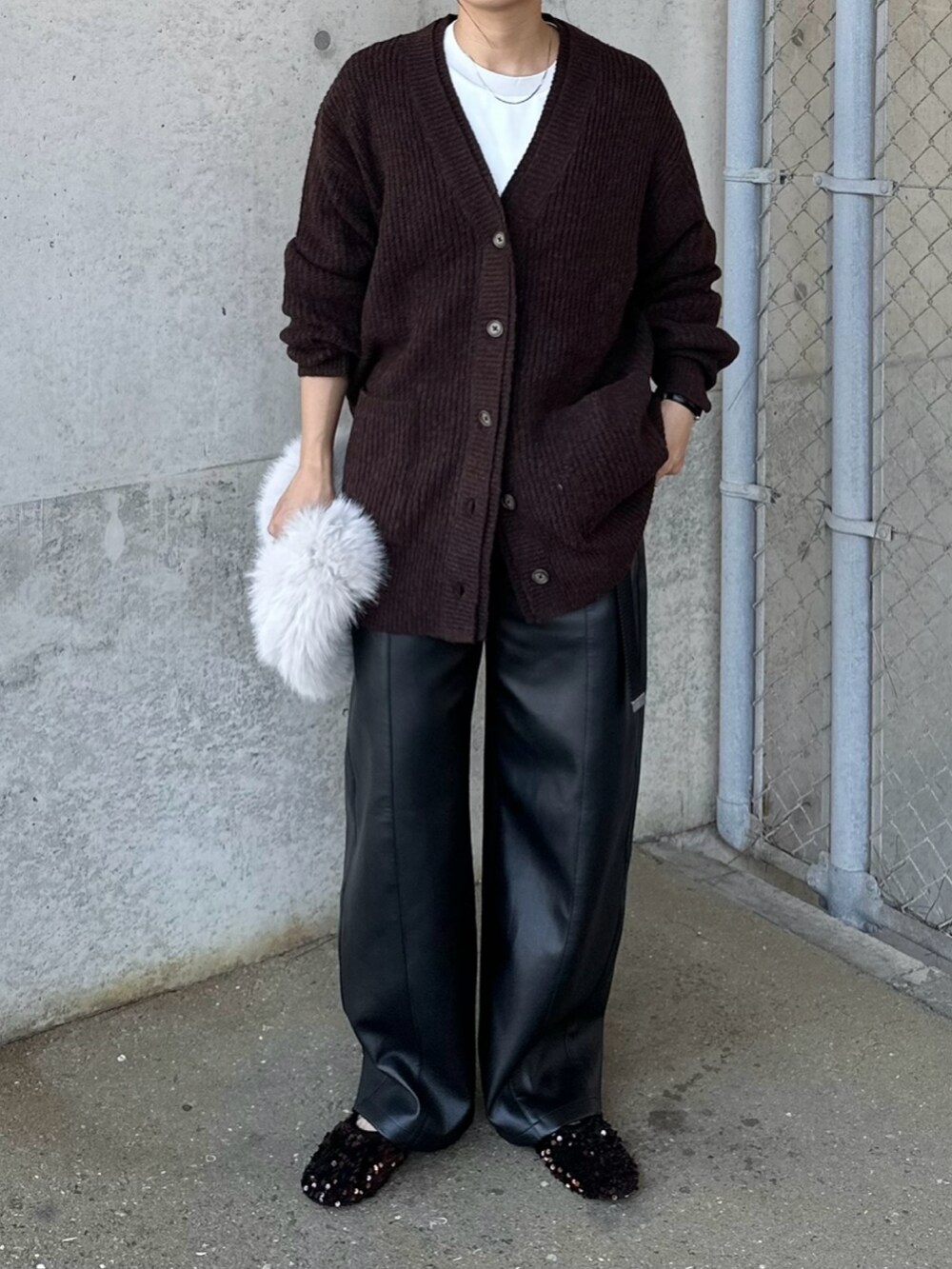 ブラック系のその他パンツ、ブラウン系のカーディガン/ボレロ、ホワイト系のハンドバッグを着用したレディースの秋コーディネートの3枚目の写真