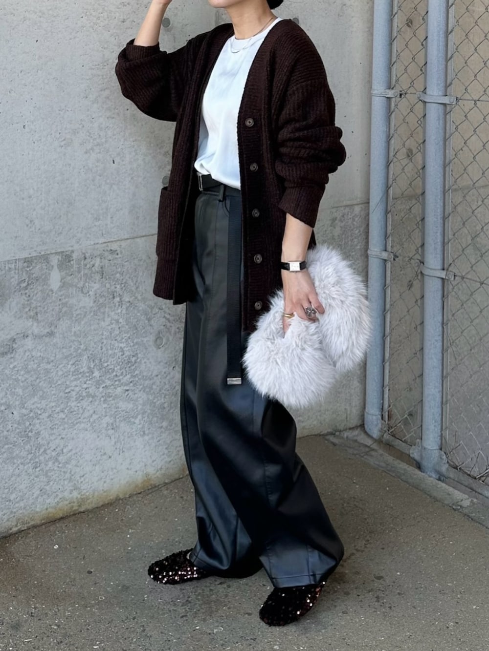 ブラック系のその他パンツ、ブラウン系のカーディガン/ボレロ、ホワイト系のハンドバッグを着用したレディースの秋コーディネートの2枚目の写真