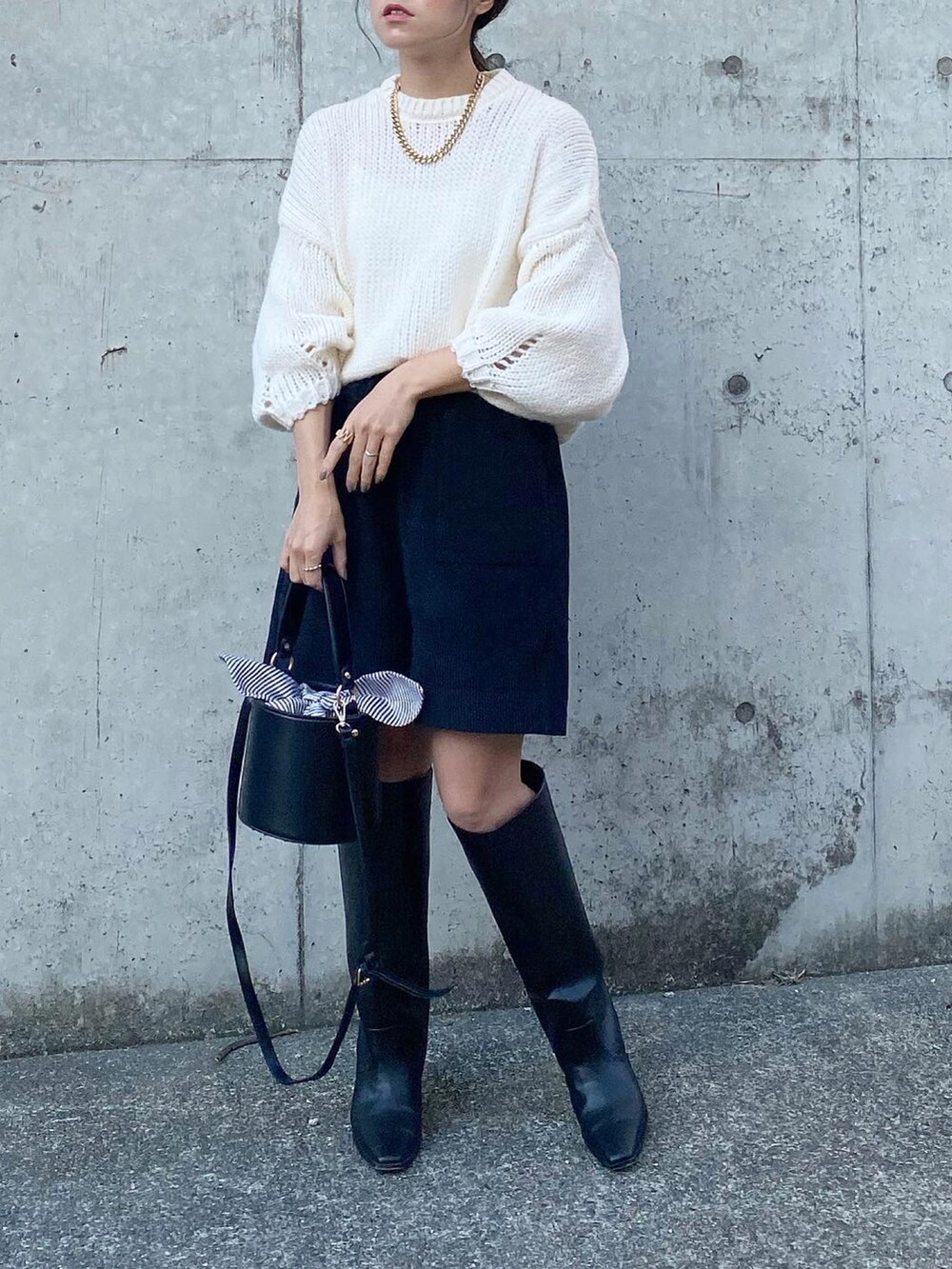 ブラック系のパンツ、ブルー系のニット/セーター、ホワイト系のシューズを着用したレディースの秋コーディネートの3枚目の写真