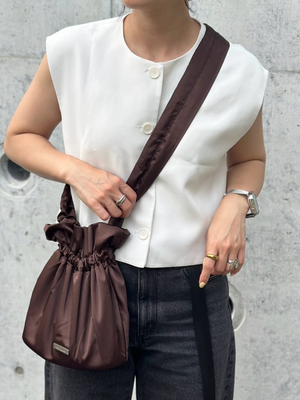 ブラック系のデニムパンツ、ホワイト系のサンダル、ホワイト系のトップスを着用したレディースの夏コーディネートの5枚目の写真