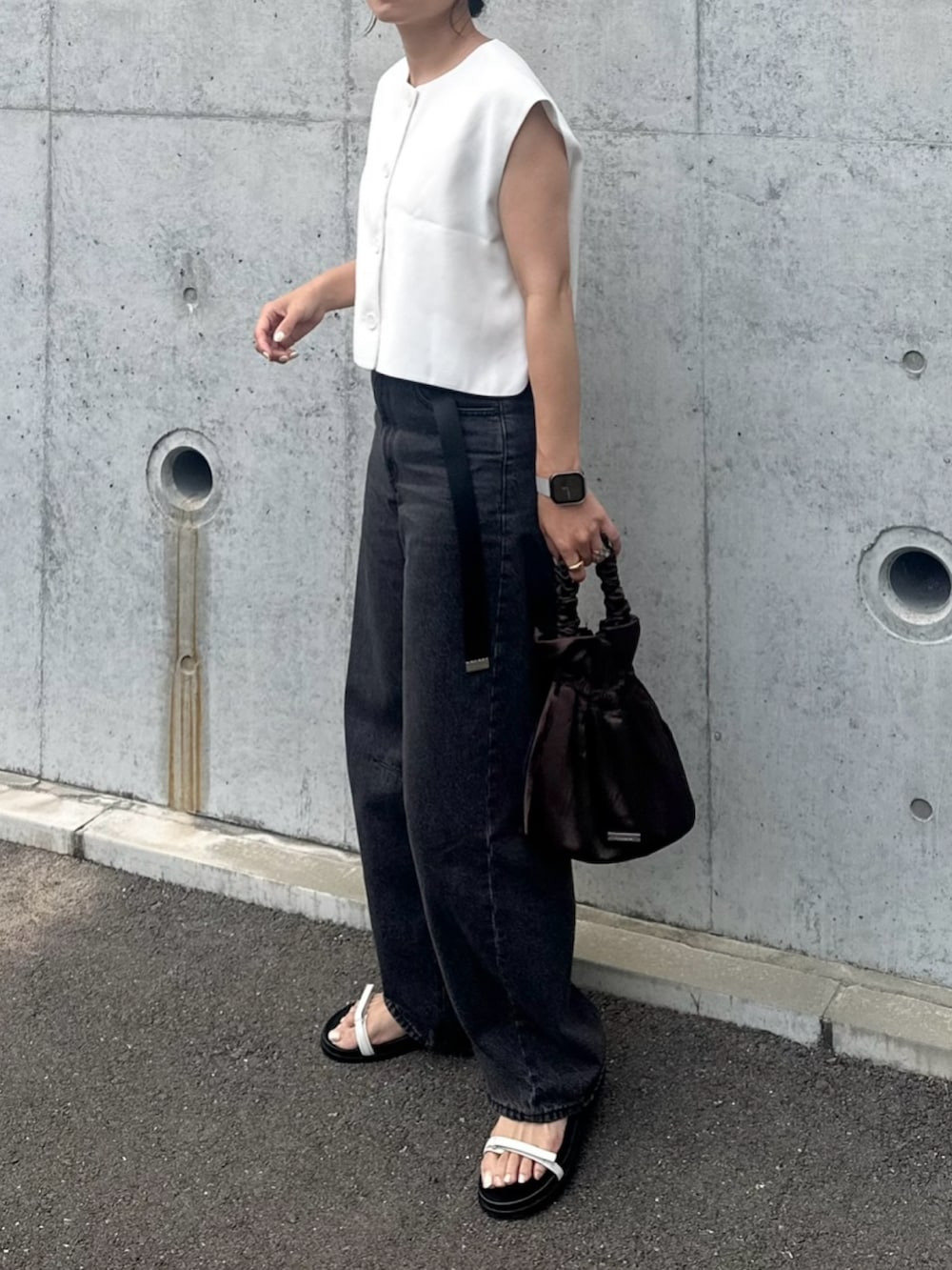 ブラック系のデニムパンツ、ホワイト系のサンダル、ホワイト系のトップスを着用したレディースの夏コーディネートの2枚目の写真