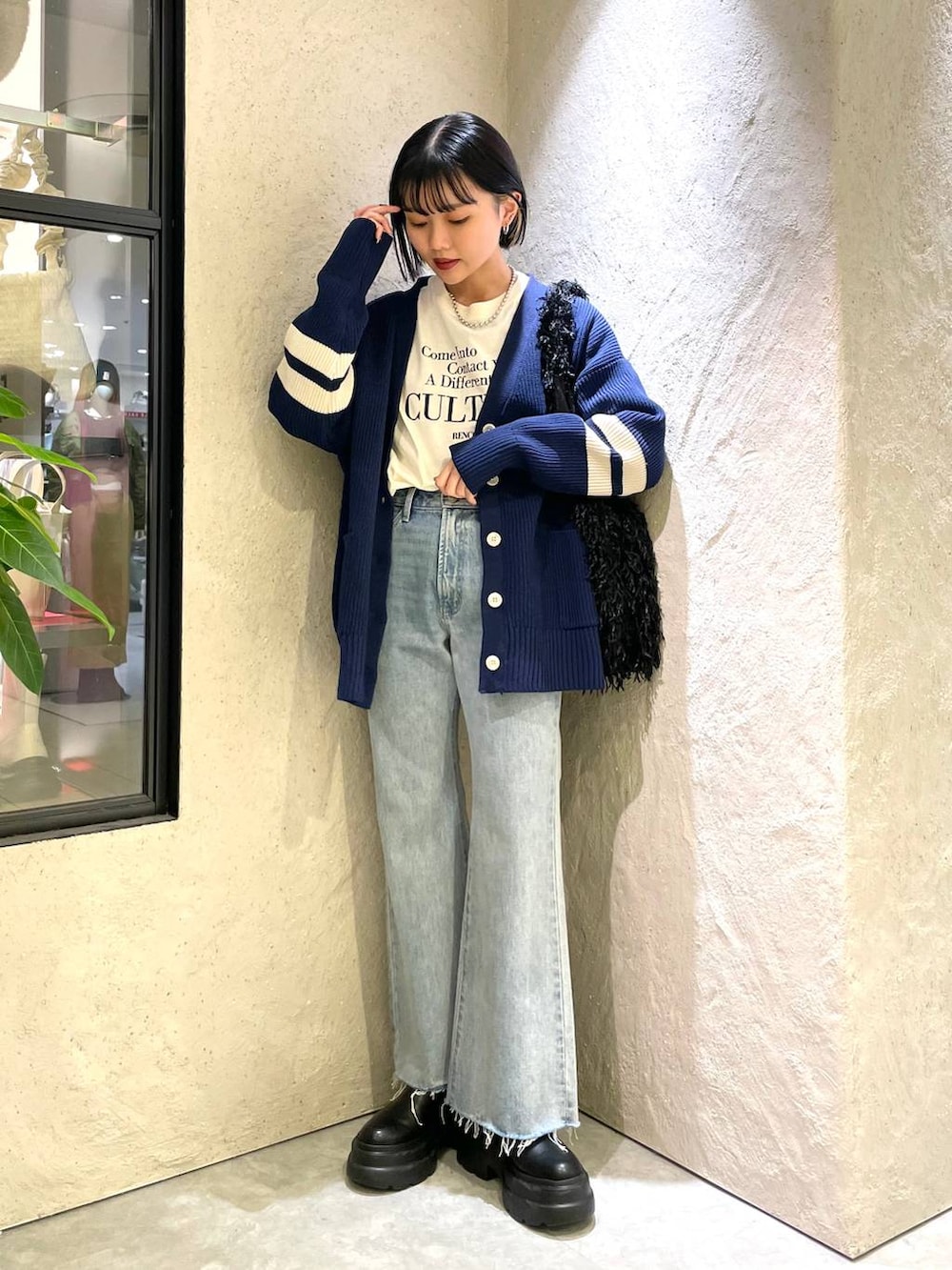 ブラック系のブーツ、ブラック系のトートバッグ、ホワイト系のTシャツ/カットソーを着用したレディースの冬コーディネートの2枚目の写真