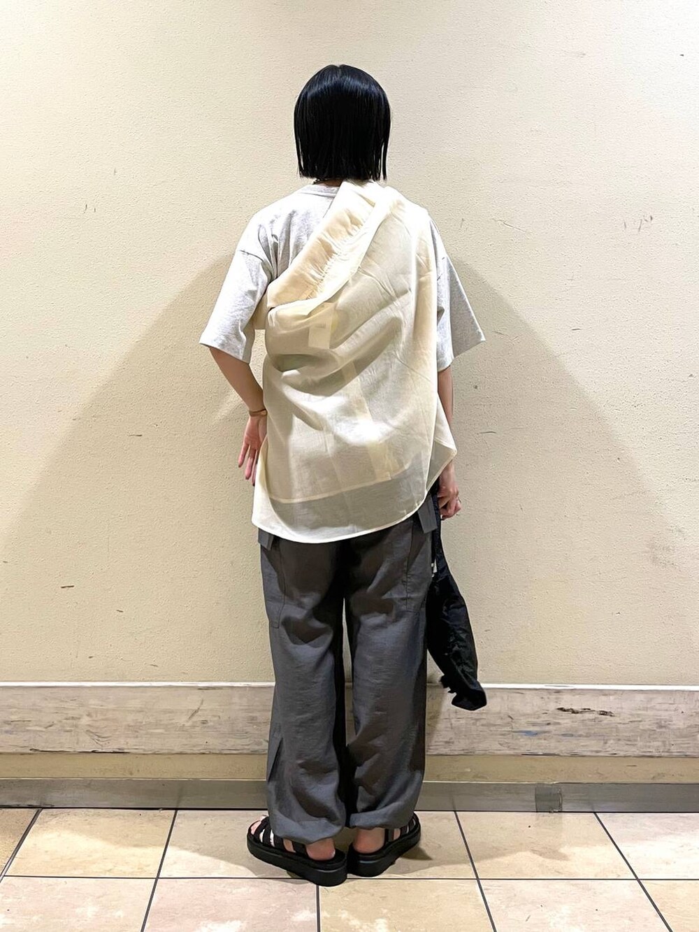 グレー系のカーゴパンツ、グレー系のTシャツ/カットソー、ブラック系のスニーカーを着用したレディースの夏コーディネートの2枚目の写真