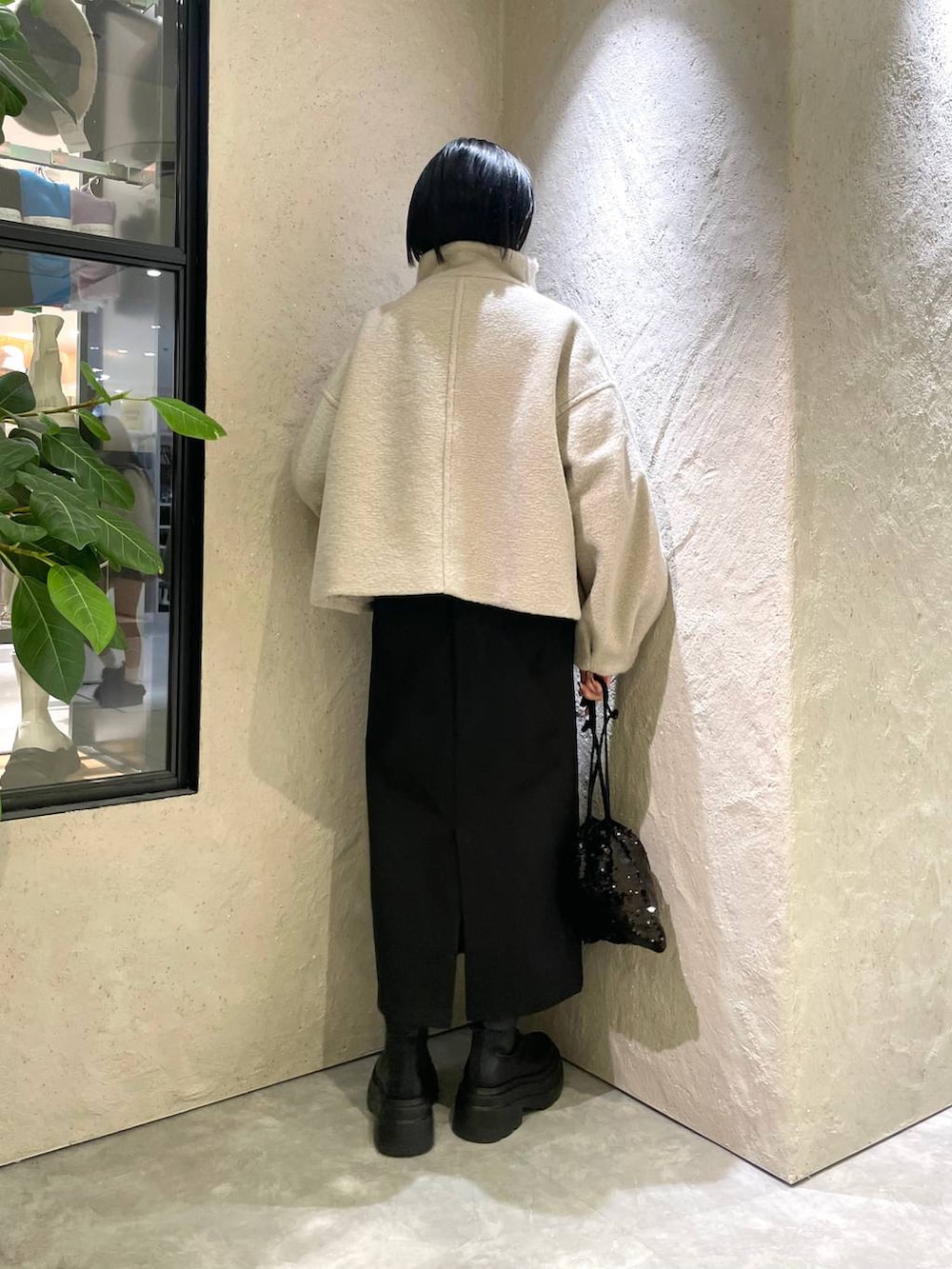 ホワイト系のブルゾン、ホワイト系のニット/セーター、ブラック系のブーツを着用したレディースの冬コーディネートの2枚目の写真