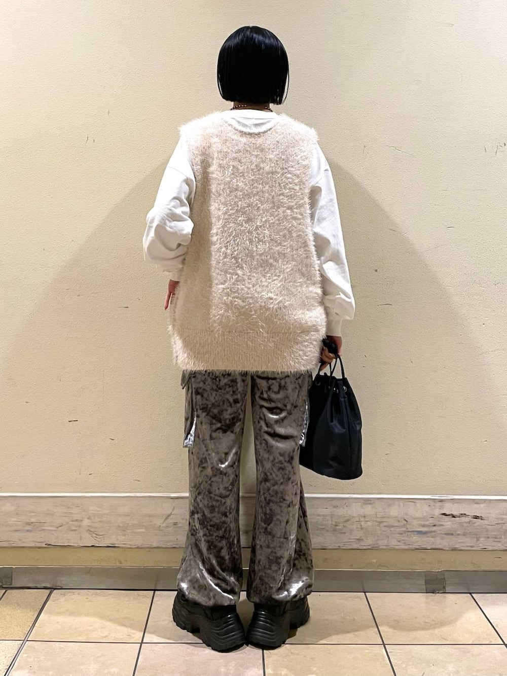 ホワイト系のTシャツ/カットソー、ホワイト系のベスト、ブラック系のスニーカーを着用したレディースの秋コーディネートの2枚目の写真