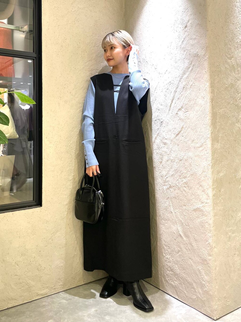 ブラック系のワンピース、ブルー系のニット/セーター、ブラック系のパンプスを着用したレディースの秋コーディネートの3枚目の写真