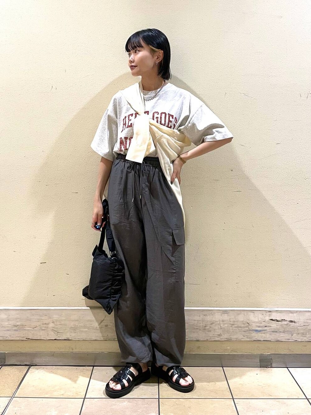 グレー系のカーゴパンツ、グレー系のTシャツ/カットソー、ブラック系のスニーカーを着用したレディースの夏コーディネートの4枚目の写真