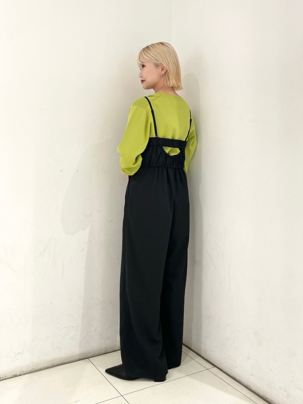 ブラック系のサロペット/オーバーオール、グリーン系のカーディガン/ボレロ、シルバー系のショルダーバッグを着用したレディースの春コーディネートの2枚目の写真