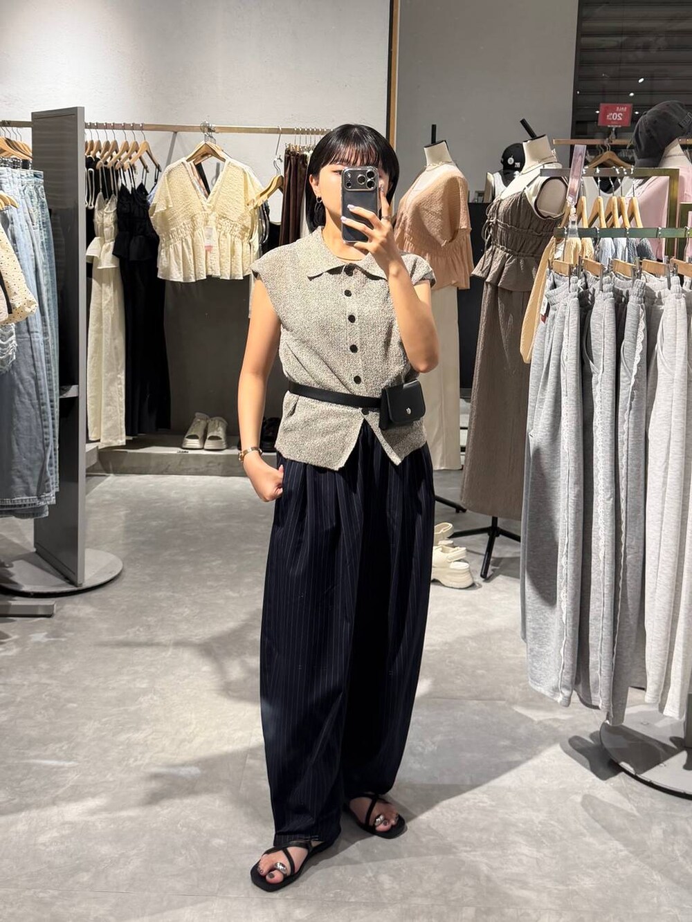 グレー系のベスト、ブルー系のその他パンツ、ブラック系のサンダルを着用したレディースの夏コーディネートの2枚目の写真