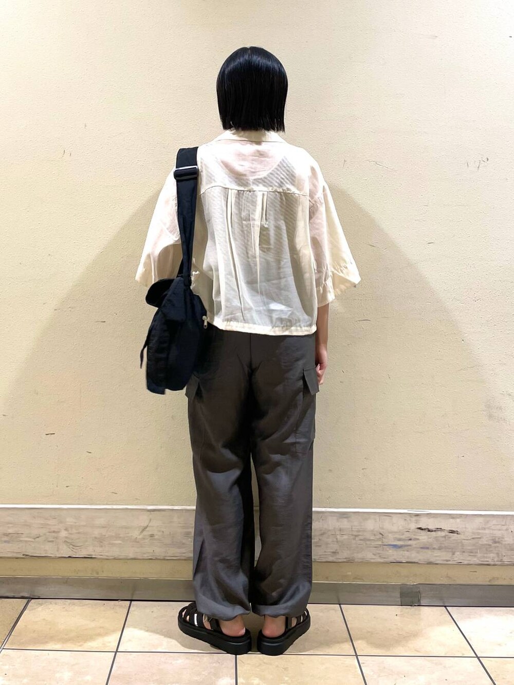 ホワイト系のシャツ/ブラウス、グレー系のカーゴパンツ、ブラック系のスニーカーを着用したレディースの夏コーディネートの2枚目の写真