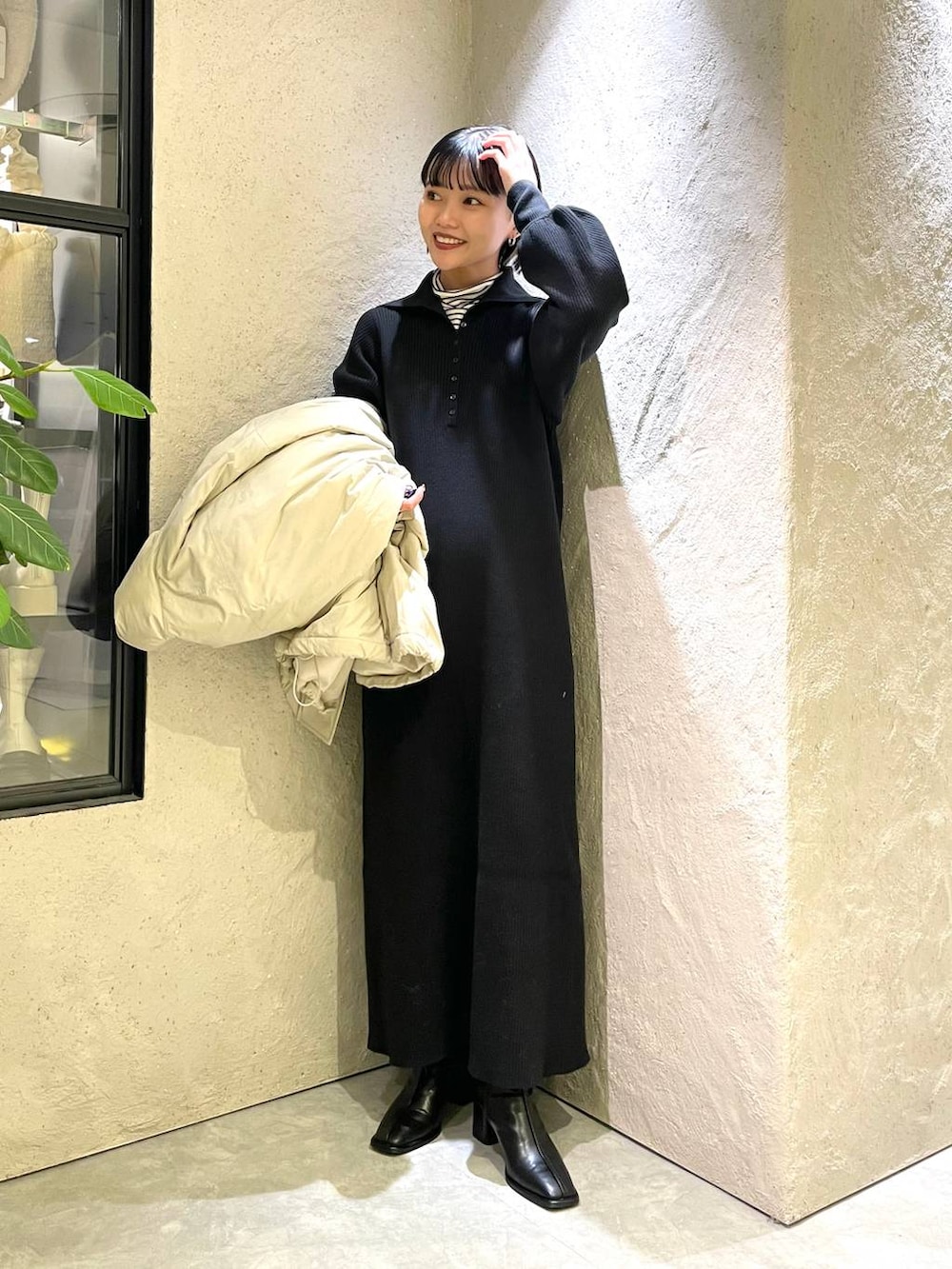 ホワイト系のTシャツ/カットソー、ホワイト系のダウンジャケット/コート、ブラック系のワンピースを着用したレディースの冬コーディネートの3枚目の写真