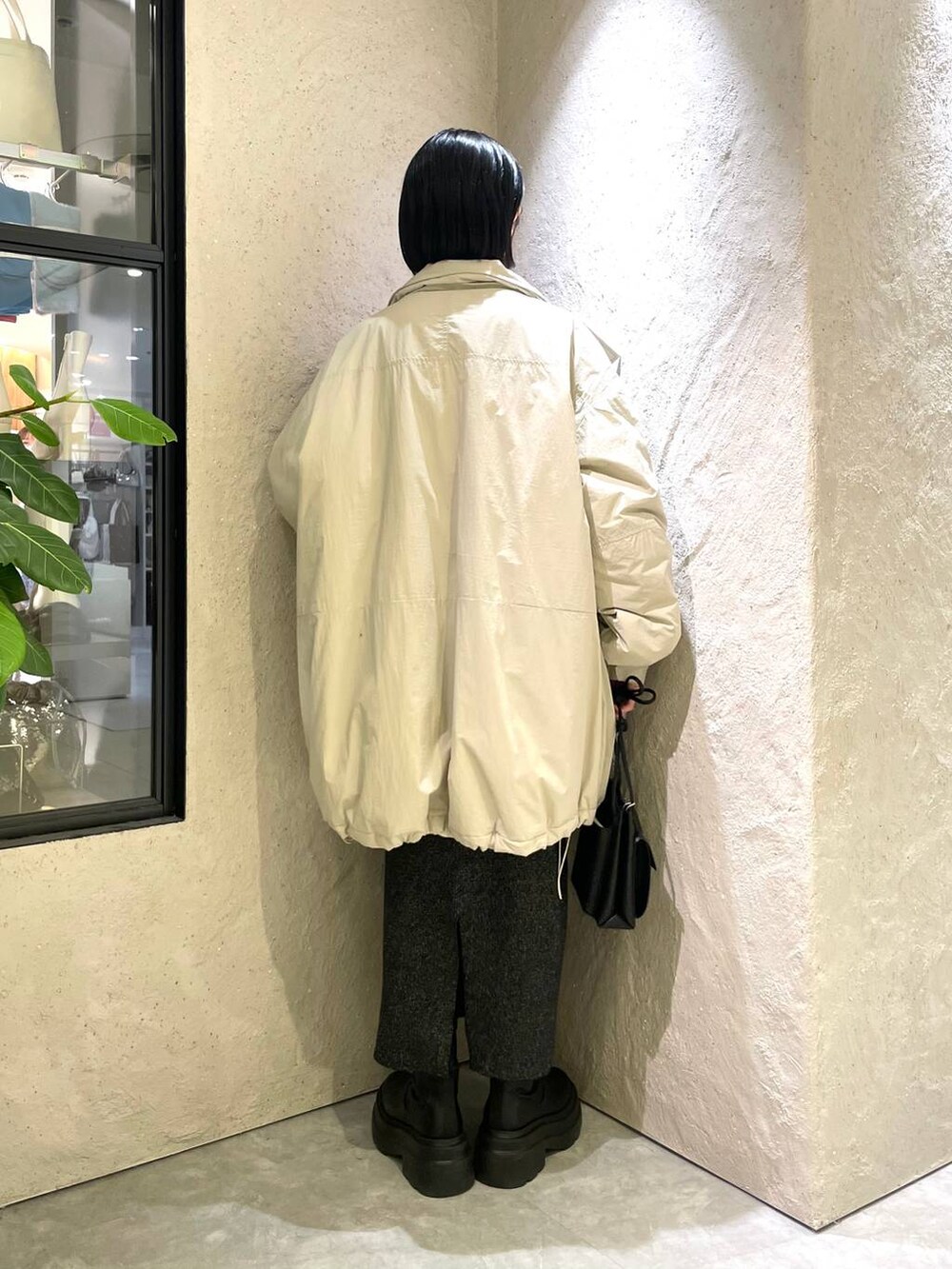 ブラック系のショルダーバッグ、ホワイト系のダウンジャケット/コート、レッド系のニット/セーターを着用したレディースの冬コーディネートの2枚目の写真